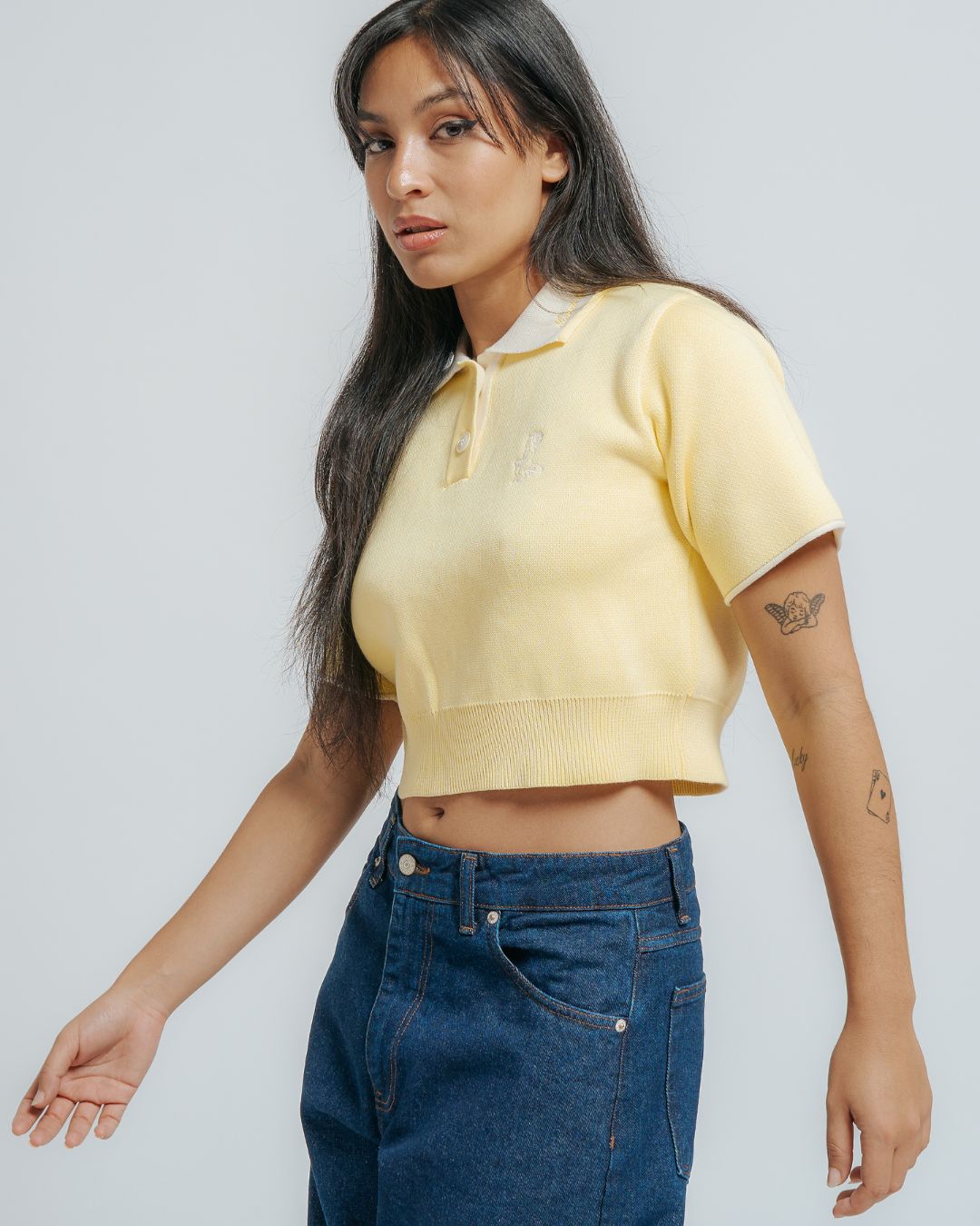 100% cotton knit
Butter colored fabric with off white contrasting details
Women's cropped fit
Classic polo collar in off white color
Two-button placket with matching cream buttons
Short sleeves with off white cuff trim
Ribbed hem for a clean finish
"Moved By Friendship" embroidery on the collar
Ikon logo embroidery on the left chest
Constructed from a soft knit fabric for a comfortable feel
Designed with a fitted silhouette that flatters the figure without being too tight
Brea