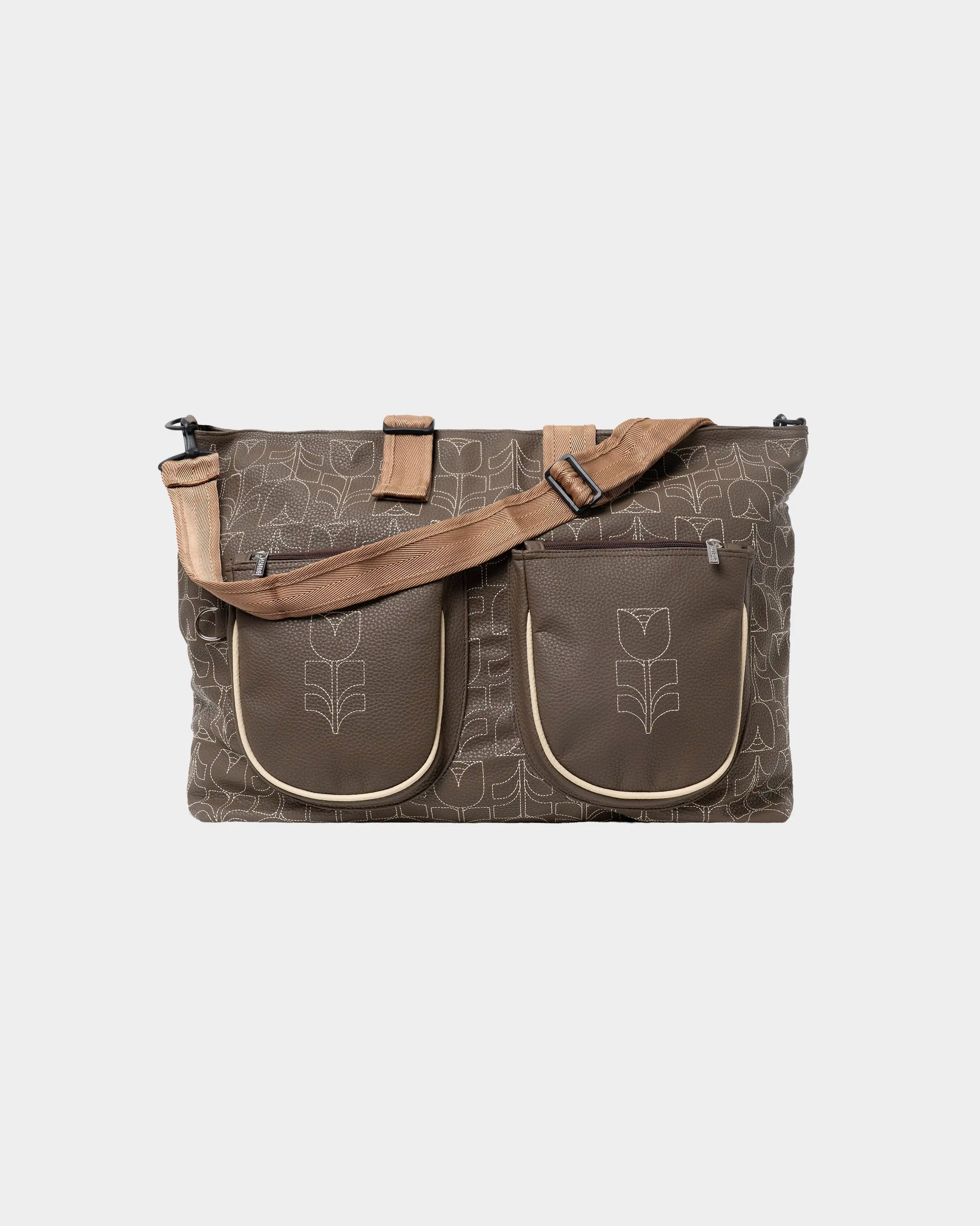 Part of the Flourish Collection
Chocolate synthetic leather exterior with all-over embroidered Flourish pattern
Adjustable shoulder strap
Spacious 40L capacity
Two exterior zip pockets
Rear zip pocket for quick-access essentials
Interior zip pocket for secure storage
Cabin-size dimensions suitable for most airlines
Weekend bag
Dimensions: 62 × 40 cm
Handmade in Portugal