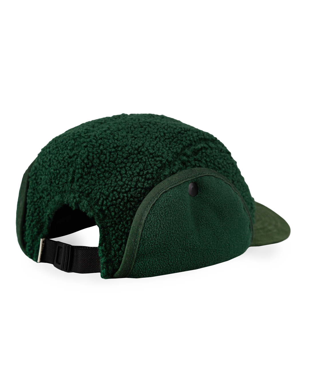 The Oreo Cap is a six-panel cap constructed with a sherpa outer shell for insulation and texture. It features ear flaps with a polar fleece lining on the inside for additional warmth and comfort. The flaps can be worn up or down, allowing for adjustable coverage. The cap has a curved brim that maintains its shape. The front panel displays the Dots Ementa logo.