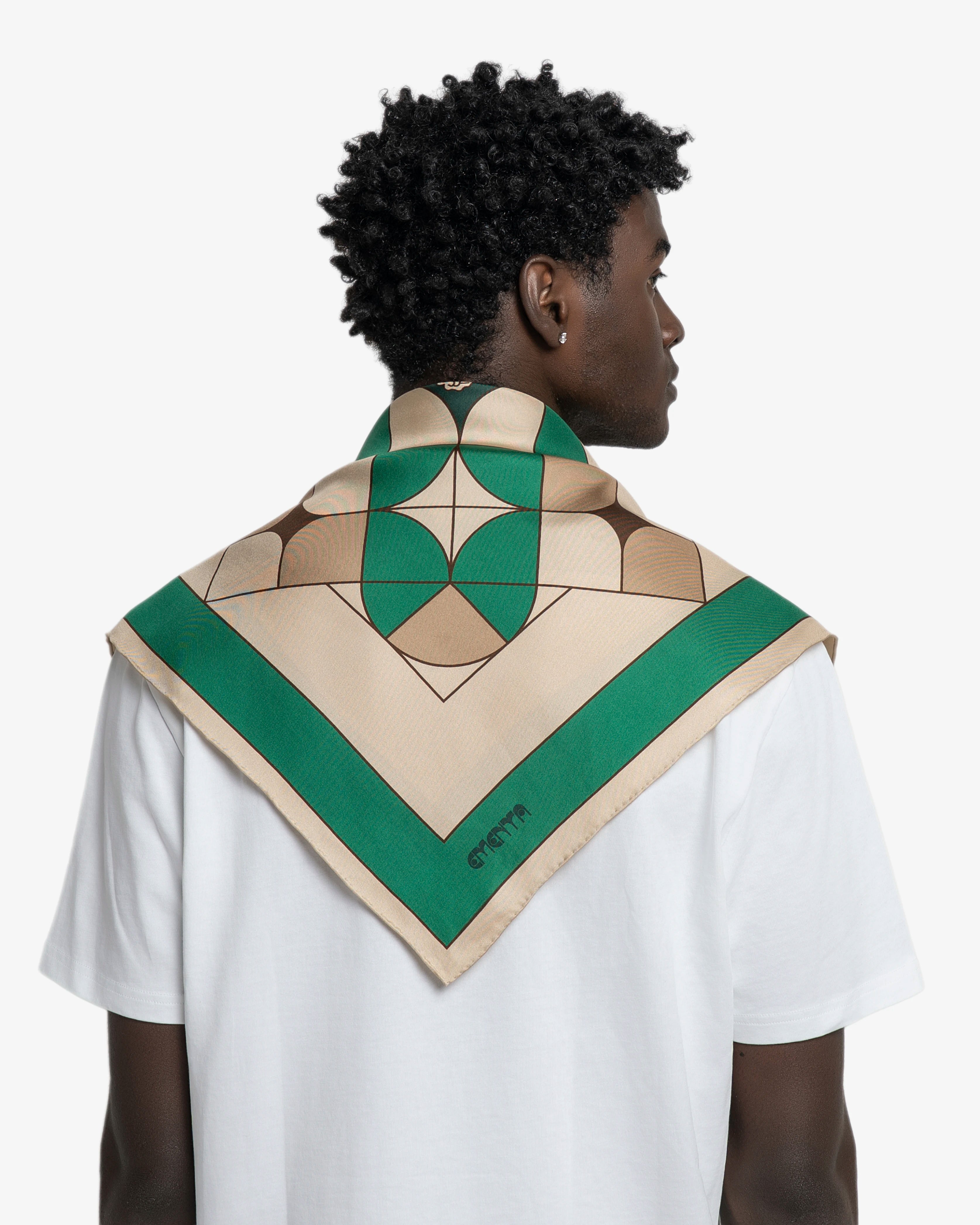 Silk scarf designed as a versatile accessory for styling around the neck, head or bag
Lightweight silk with a smooth, fluid hand feel
Square shape with a printed geometric pattern combining green, beige and dark brown tones
Origins artwork incorporates Ementa lettering, graphic symbols and repeated geometric forms
Finished with a contrasting green border framing the central pattern
90cmx90cm