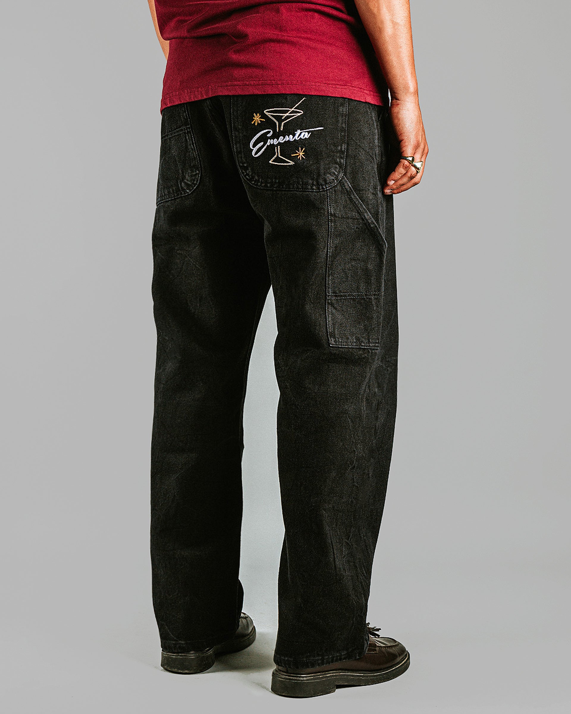 Relaxed-fit jeans made from black marble-washed denim, designed for comfort and durability with a focus on providing the perfect fit. The jeans feature the cocktail design embroidered on the back pocket for added detail. Equipped with two back pockets, two front pockets, and one side pocket for practical storage.