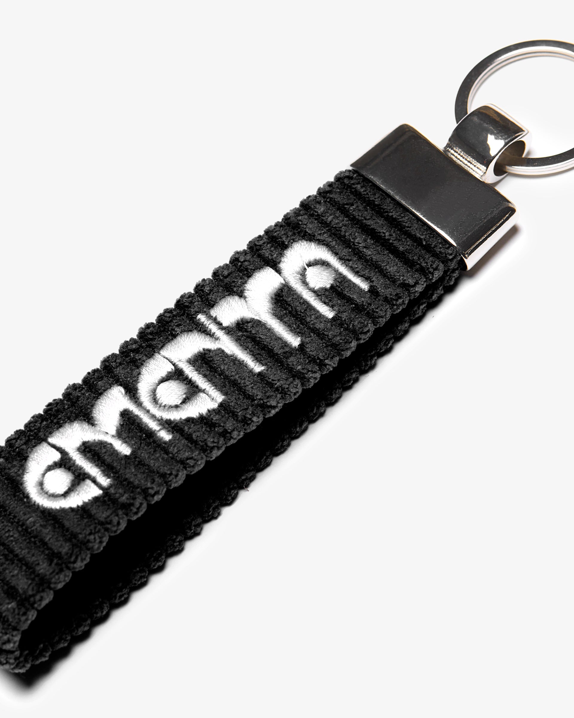 A corduroy keychain with the Ementa Dots logo in a metal finish.
Comes with a sturdy key ring. 
Simple, durable, and easy to carry.
The corduroy band measures 10,5cm in width and 2,5cm in length.