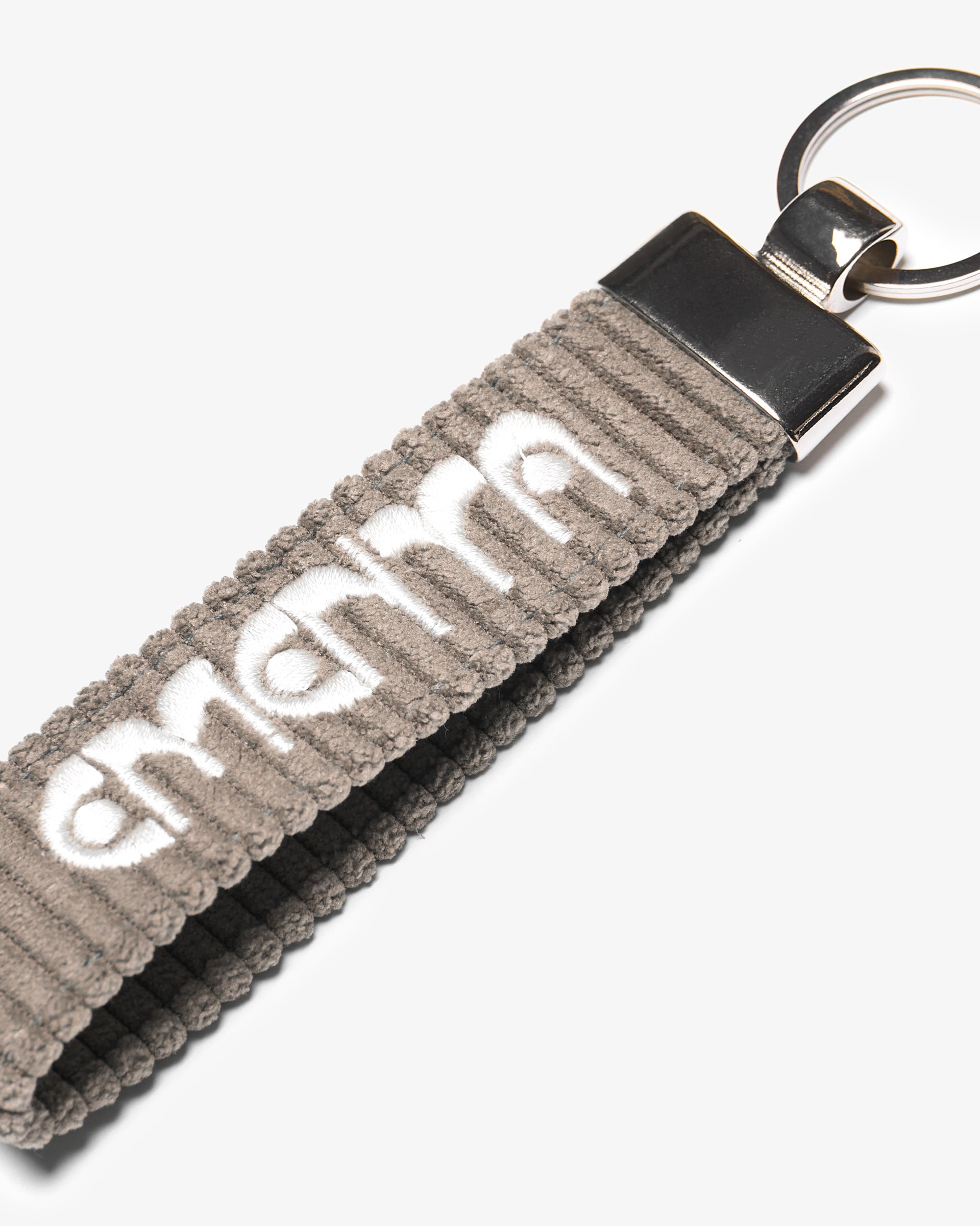 A corduroy keychain with the Ementa Dots logo in a metal finish.
Comes with a sturdy key ring. 
Simple, durable, and easy to carry.
The corduroy band measures 10,5cm in width and 2,5cm in length.