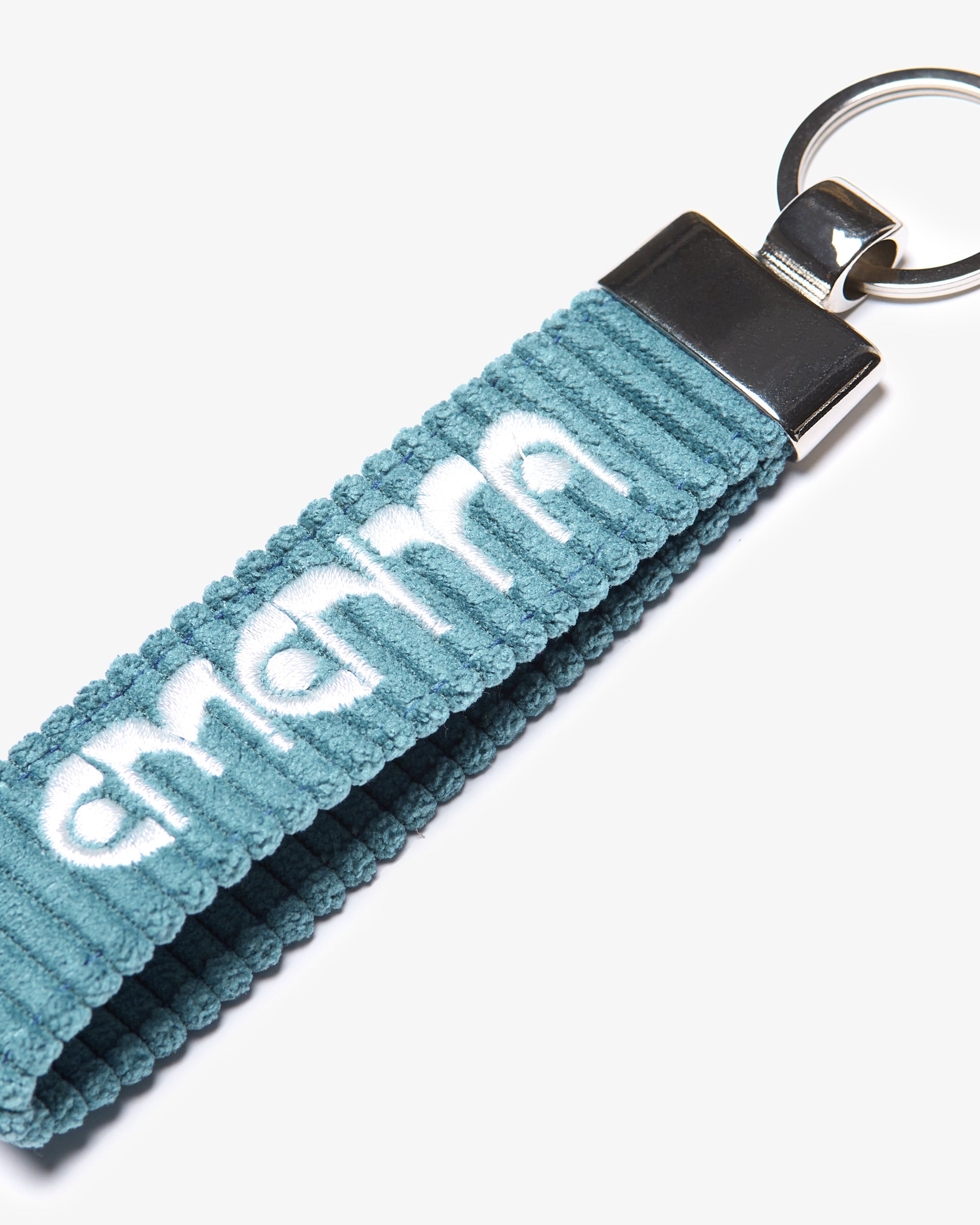 A corduroy keychain with the Ementa Dots logo in a metal finish.
Comes with a sturdy key ring. 
Simple, durable, and easy to carry.
The corduroy band measures 10,5cm in width and 2,5cm in length.