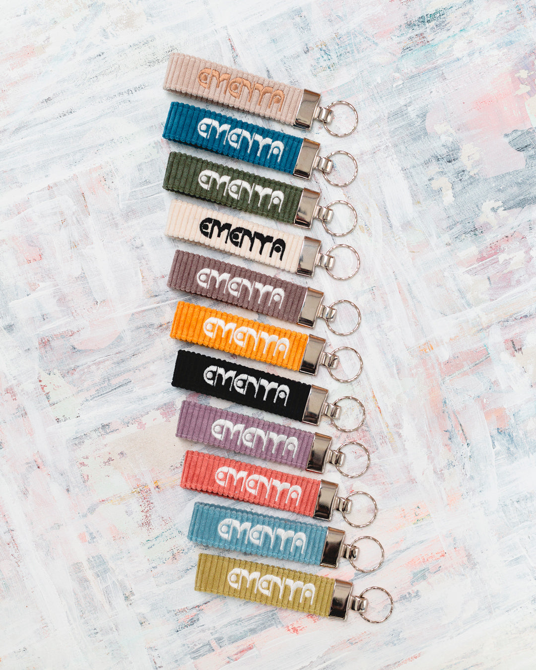 A corduroy keychain with the Ementa Dots logo in a metal finish.
Comes with a sturdy key ring.
Simple, durable, and easy to carry.
The corduroy band measures 10,5cm in width and 2,5cm in length.