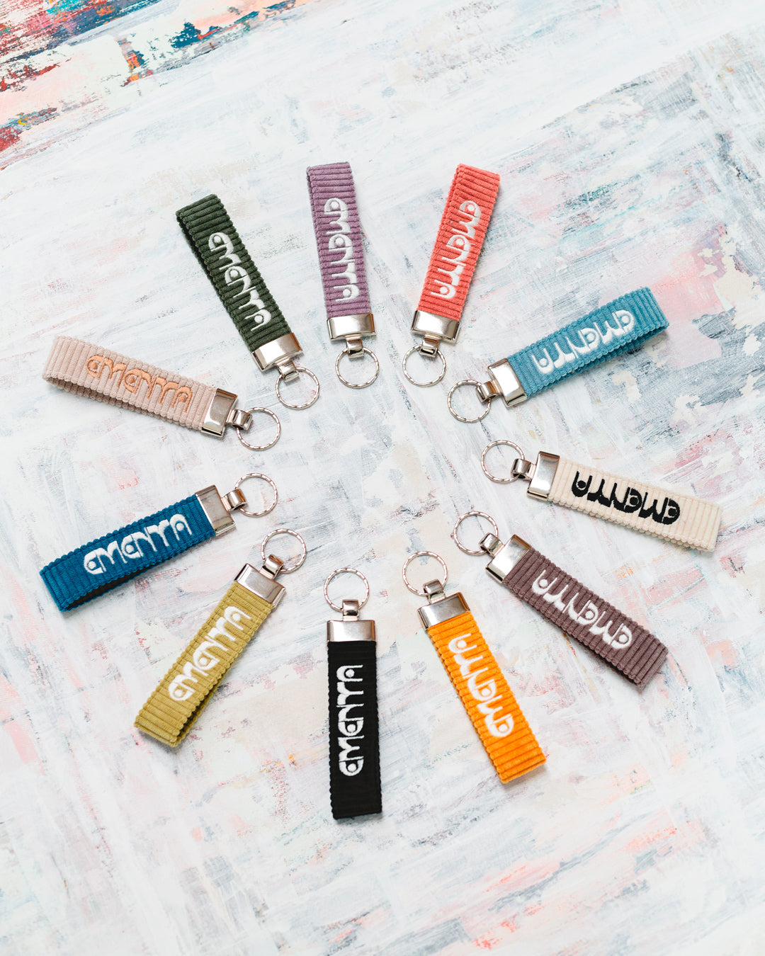 A corduroy keychain with the Ementa Dots logo in a metal finish.
Comes with a sturdy key ring.
Simple, durable, and easy to carry.
The corduroy band measures 10,5cm in width and 2,5cm in length.