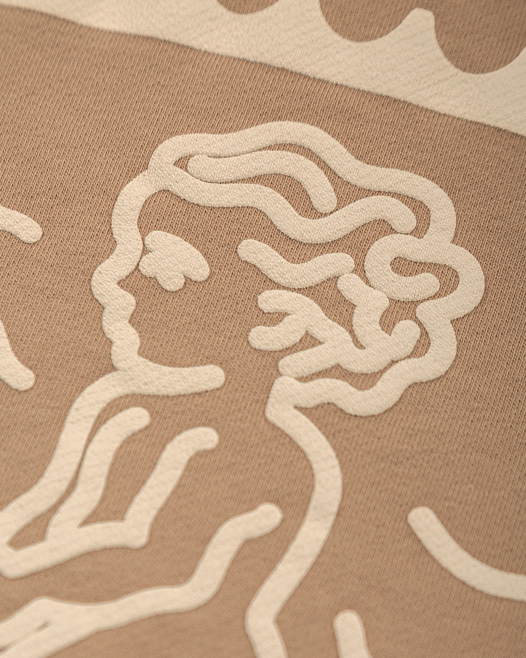 Crafted from heavyweight 100% cotton, this camel hoodie is designed to hold its shape and resist frequent wear, offering durability and a cozy feel. The interior is lined with heavyweight brushed fleece for added warmth. It features an embossed print with a textured Ikon stamp and an embroidered signature on the right wrist.