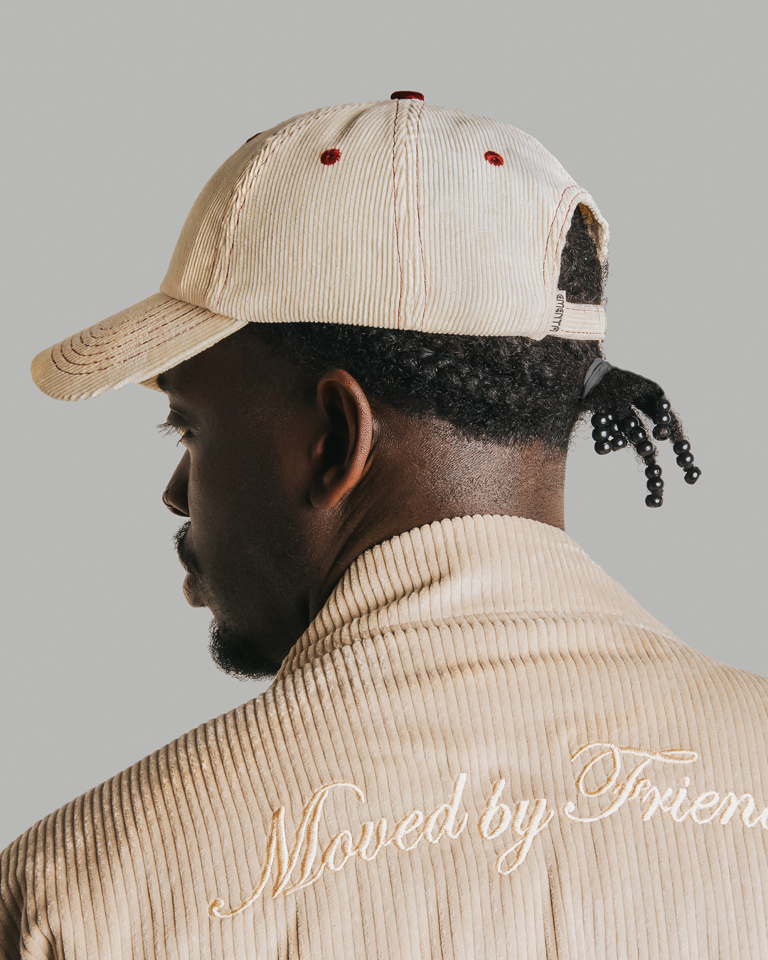 Off-white corduroy with burgundy stitching running through the seams. The Liberation design is embroidered in deep burgundy on the front, standing out against the soft texture. Six-panel build, curved brim, and an adjustable strap at the back. 100% cotton corduroy.
