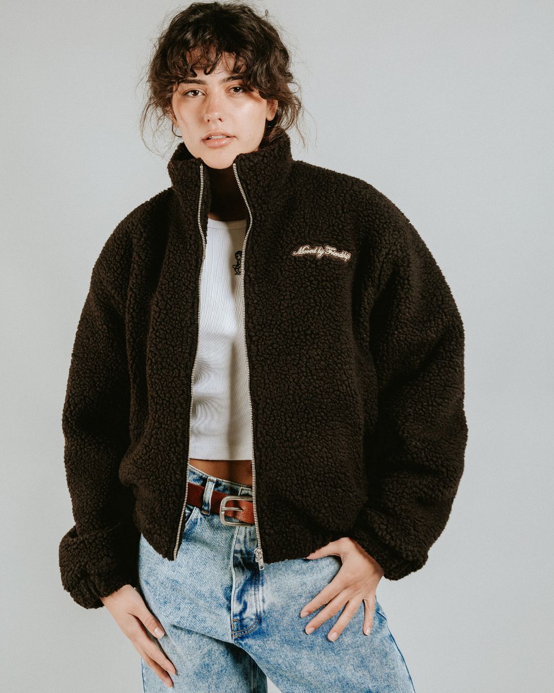 The Oreo Friendship Polar Jacket combines warmth and comfort with its thick brown polar exterior. Inside, puffed diamond stitching adds texture and durability, enhancing its cozy feel.
Elasticated wrists and hips provide a customizable fit, while two exterior pockets and one interior pocket offer convenient storage. The chest features the motto "Moved by Friendship" embroidered, and the back showcases the dragged effect Ikon logo.