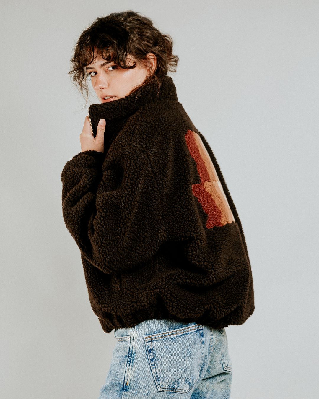 The Oreo Friendship Polar Jacket combines warmth and comfort with its thick brown polar exterior. Inside, puffed diamond stitching adds texture and durability, enhancing its cozy feel.
Elasticated wrists and hips provide a customizable fit, while two exterior pockets and one interior pocket offer convenient storage. The chest features the motto "Moved by Friendship" embroidered, and the back showcases the dragged effect Ikon logo.