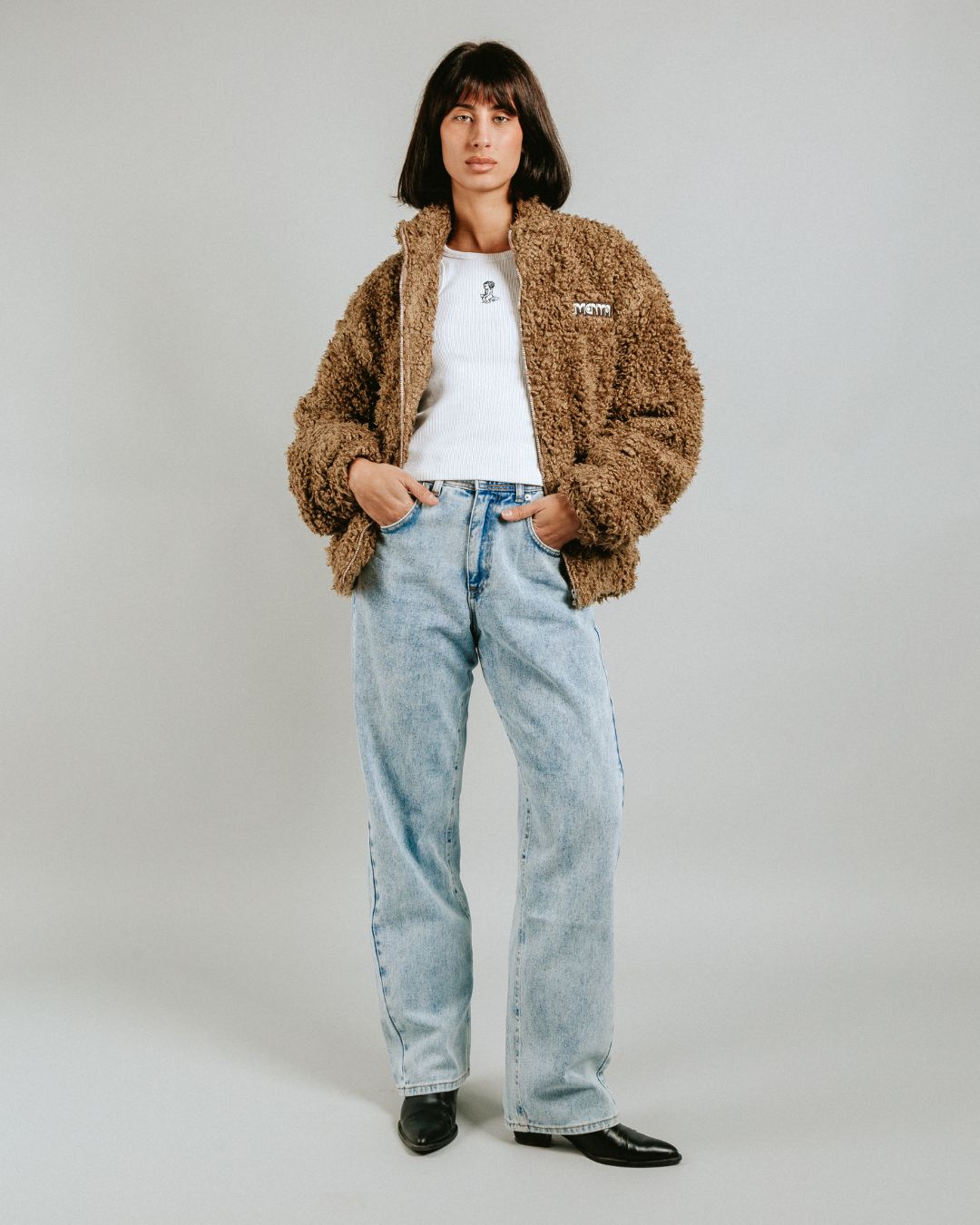 The Poncha Jacket in camel is designed for warmth and comfort with its soft camel fur exterior. Inside, it features diamond stitching for added texture and durability.
It offers elasticated wrists and hips for a customizable fit, two exterior pockets and an interior pocket for convenient storage.