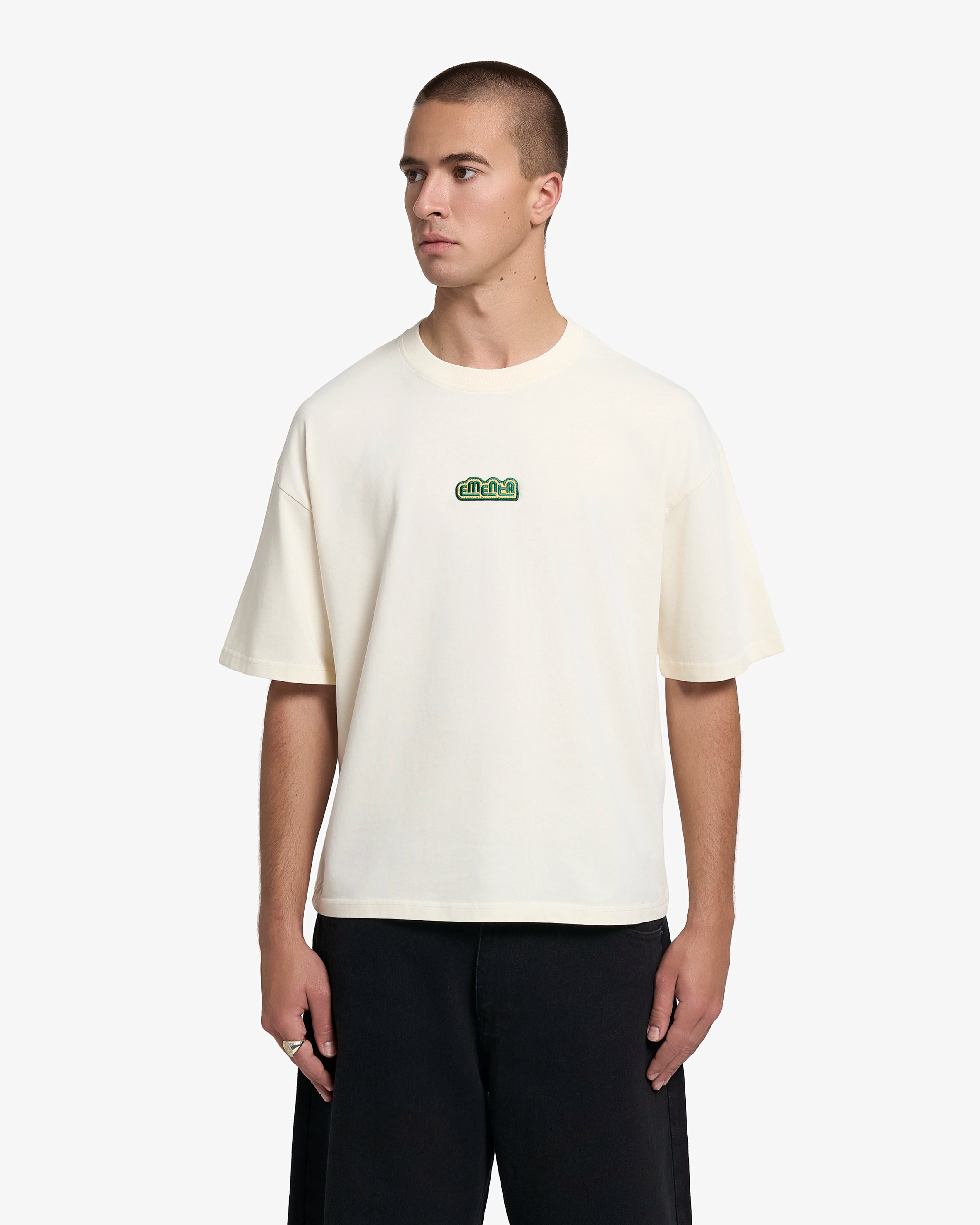 Short-sleeve t-shirt with a clean, minimal construction
Cotton jersey with a dense, structured feel
Boxy fit with a wider, slightly cropped silhouette
Embroidered patch applied on the chest area
Off-white colour with a uniform finish
Machine wash cold. Do not tumble dry
Made in Portugal