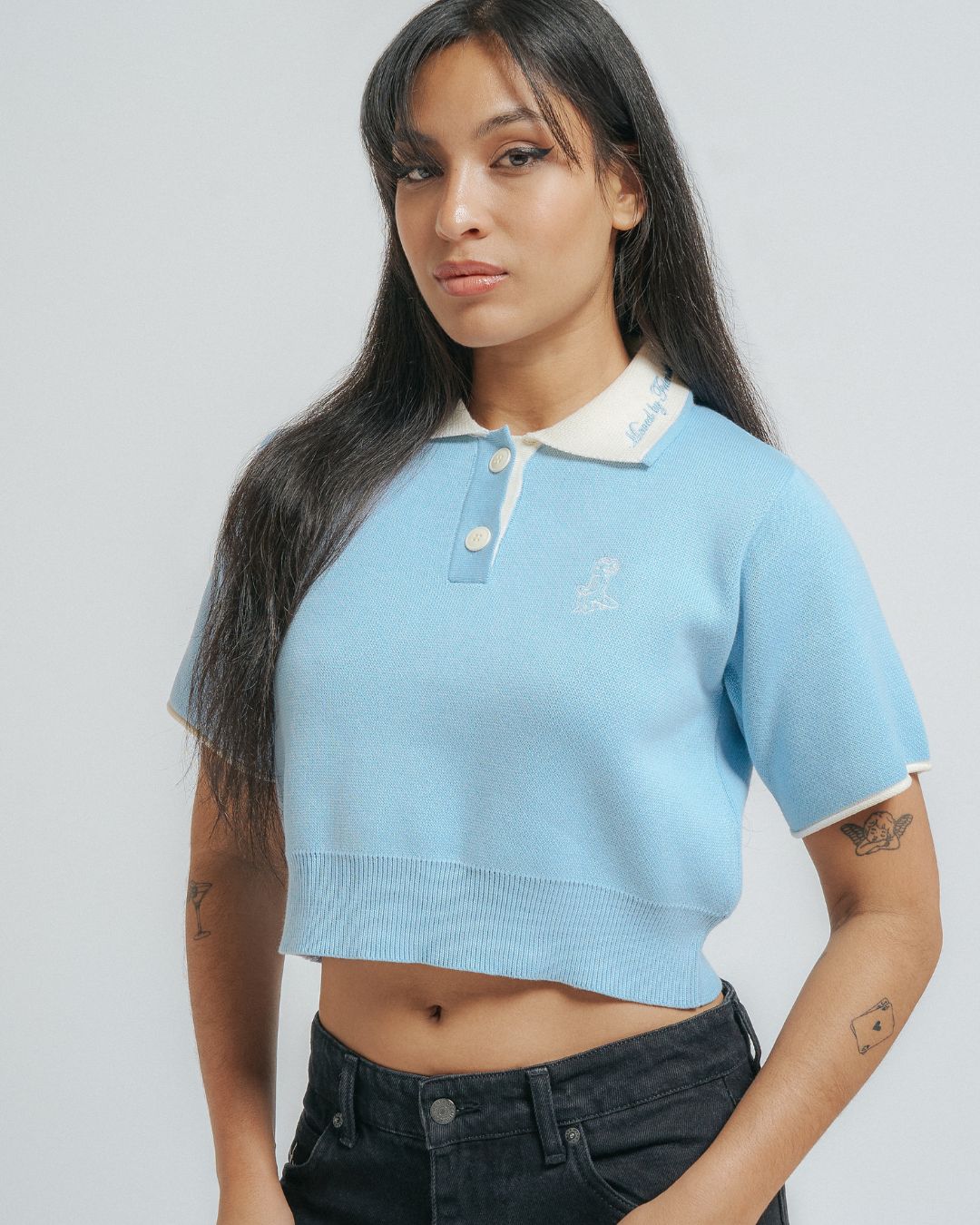 100% cotton knit
Light blue knit fabric with cream contrasting details
Women's cropped fit
Classic polo collar in off white color
Two-button placket with matching cream buttons
Short sleeves with off white cuff trim
Ribbed hem for a clean finish
"Moved By Friendship" embroidery on the collar
Ikon logo embroidery on the left chest
Constructed from a soft knit fabric for a comfortable feel
Designed with a fitted silhouette that flatters the figure without being too tigh