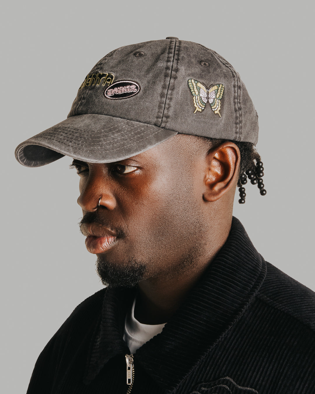 The Dots Patch Cap is a classic six-panel cap crafted from 100% cotton, ensuring a comfortable fit and durable wear. It comes in a sleek black color, enhanced by a curved brim. The cap is decorated with multiple embroidered patches, adding character to the design.