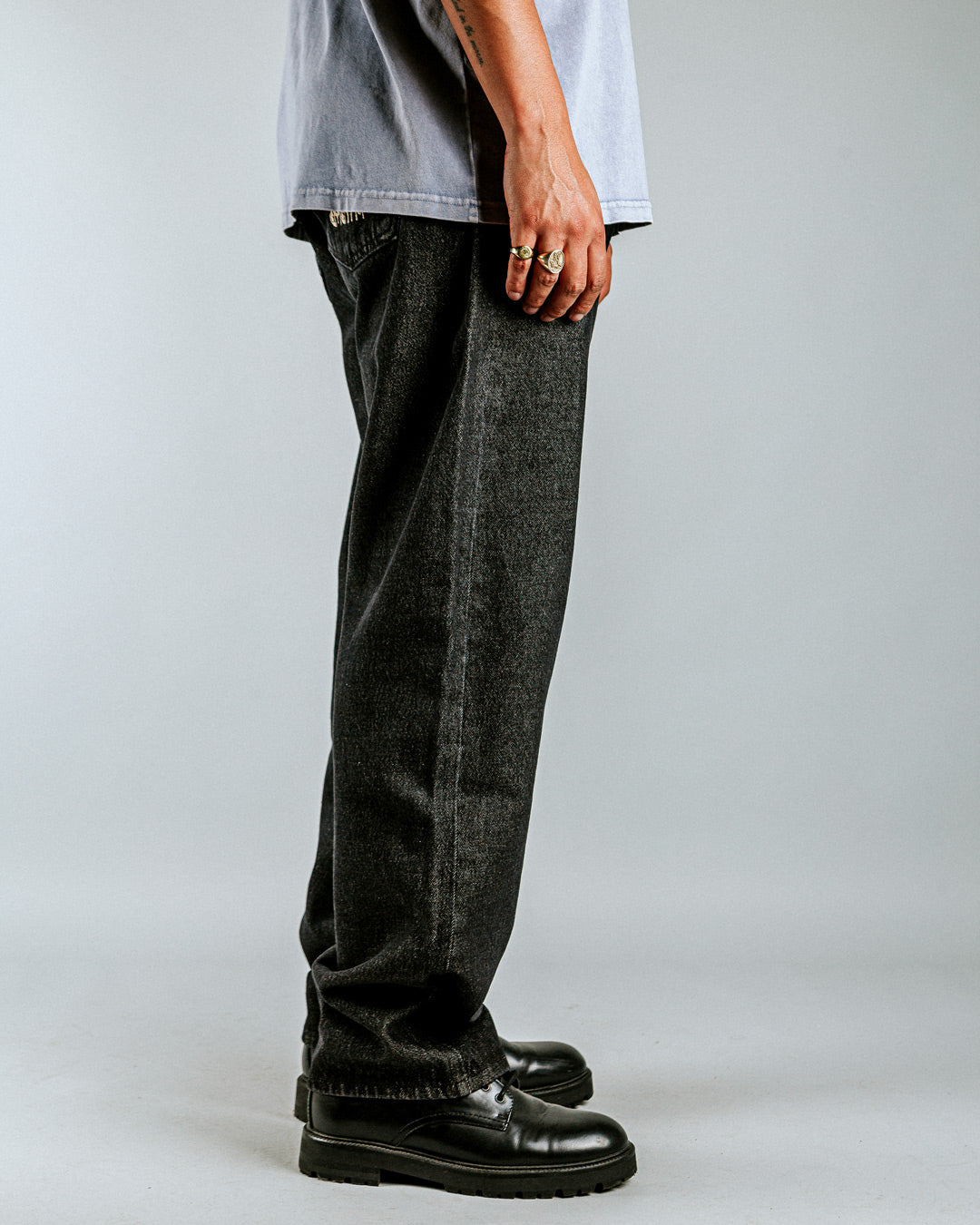 Relaxed-fit jeans made from black rinsed denim, designed for comfort and durability with a focus on providing the perfect fit. The jeans feature embroidered logos on the front and back for added detail.