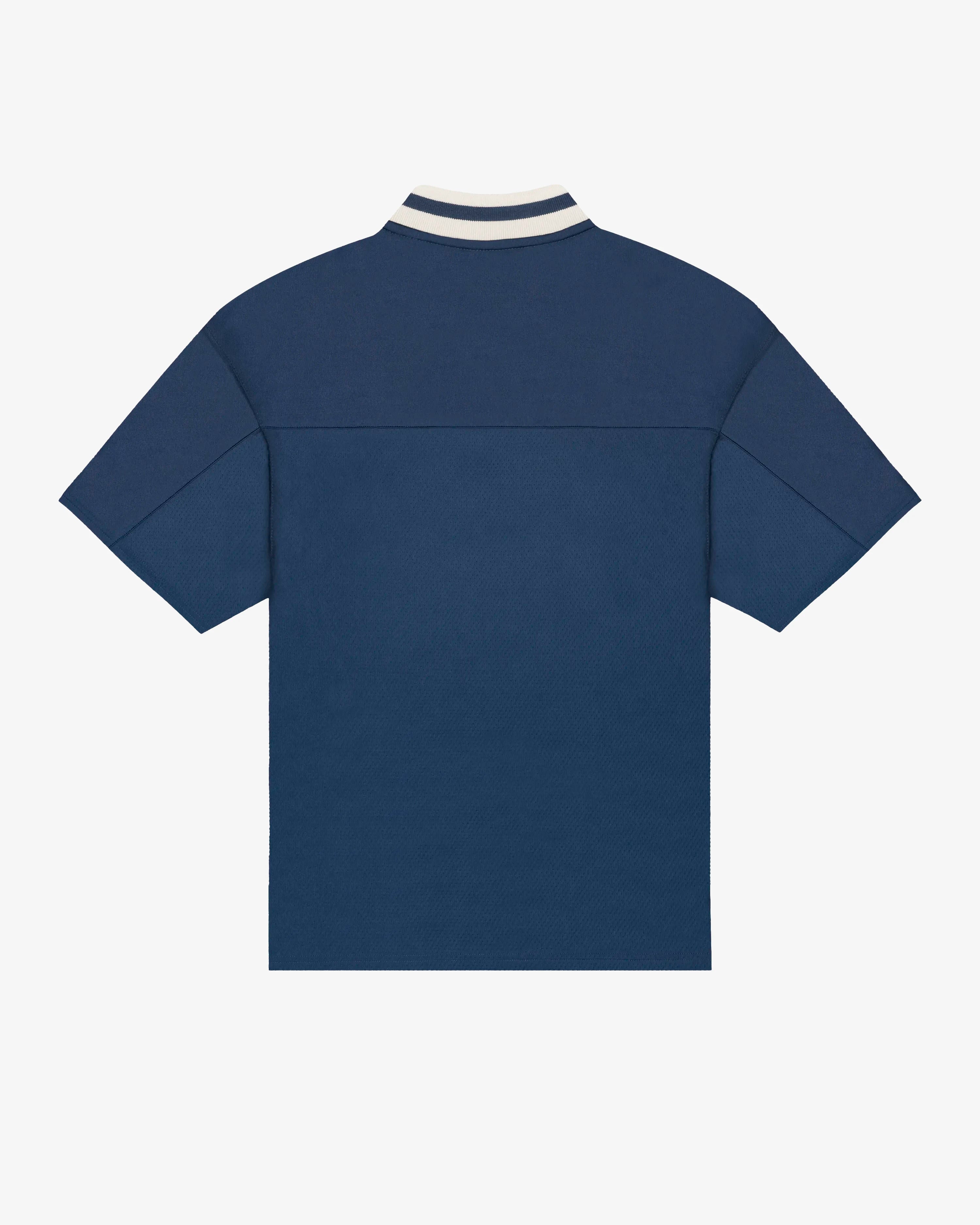 Breathable mesh fabric on the lower half, cotton-poly blend on the upper half
Oversized fit
Navy color with off-white accents
Large 'EMENTA' embroidery on the chest, small branded detail embroidered on the bottom right
V-neck collar with double green stripes
Oversized sleeves for a relaxed silhouette
Part of a kit – matching shorts available online
Machine washable