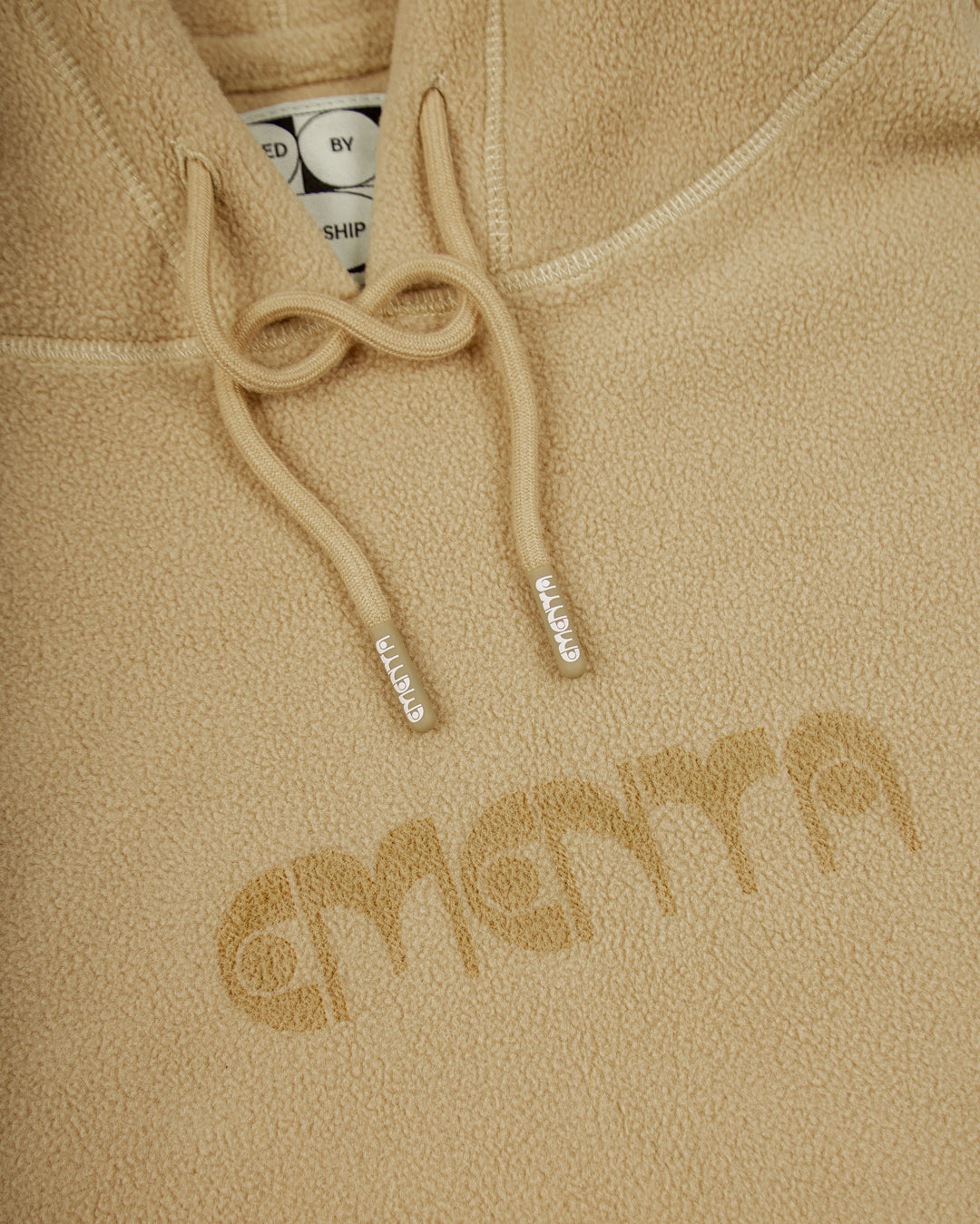 Polar hoodie with a baggy fit, designed for ultimate comfort and warmth. The front features the Ementa logo, while the back showcases the motto, "Moved by Friendship." It also includes a branded hoodie lace, adjustable cuffs, and waist, and two zips on the front pocket, making it both practical and cozy.