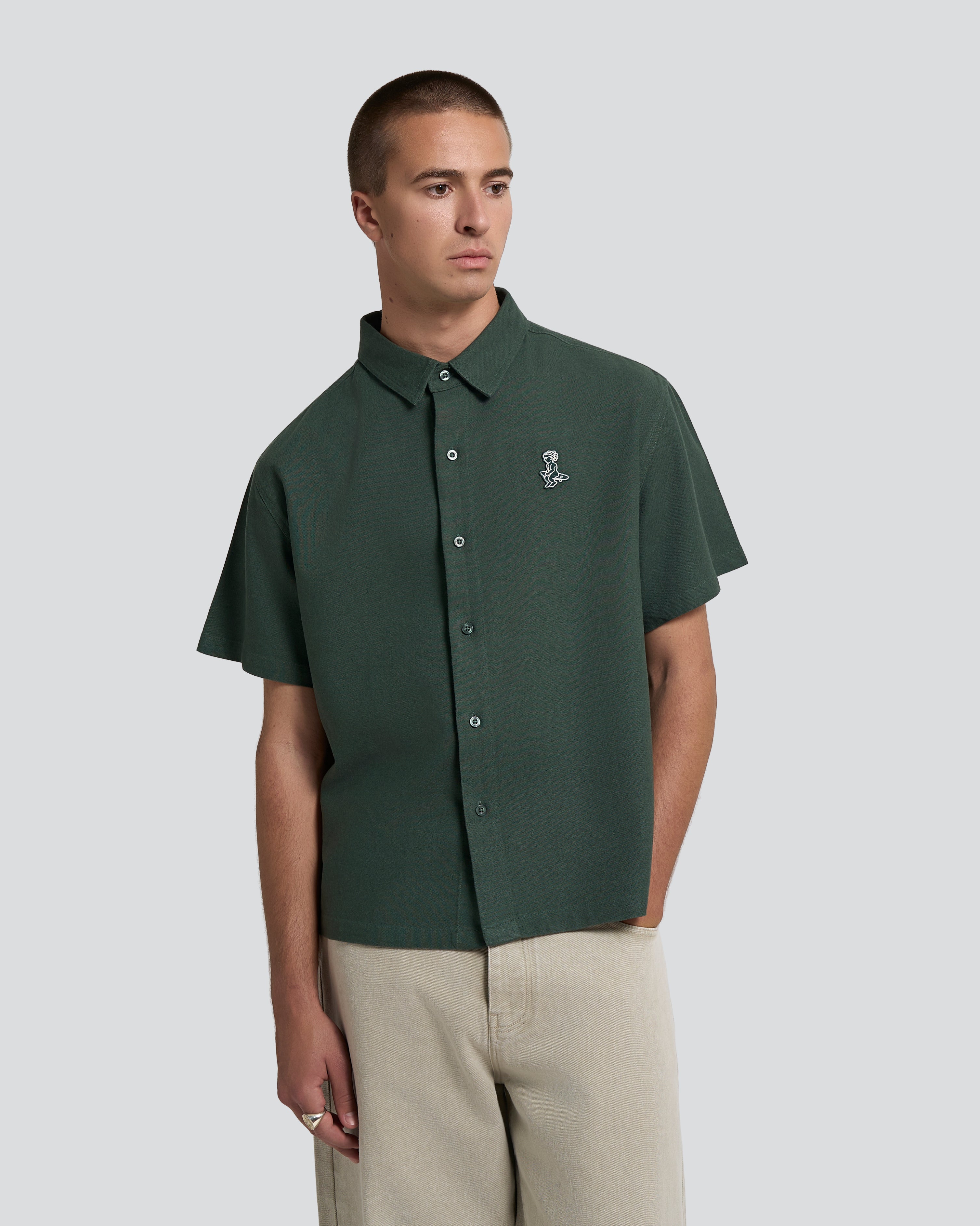 Short sleeve button-up shirt with a clean, structured appearance
100% cotton fabric with a textured weave and dry hand feel
Relaxed fit with a straight cut for ease of movement
Chest embroidered patch featuring the Ikon logo
Deep green tone with a matte finish and tonal buttons