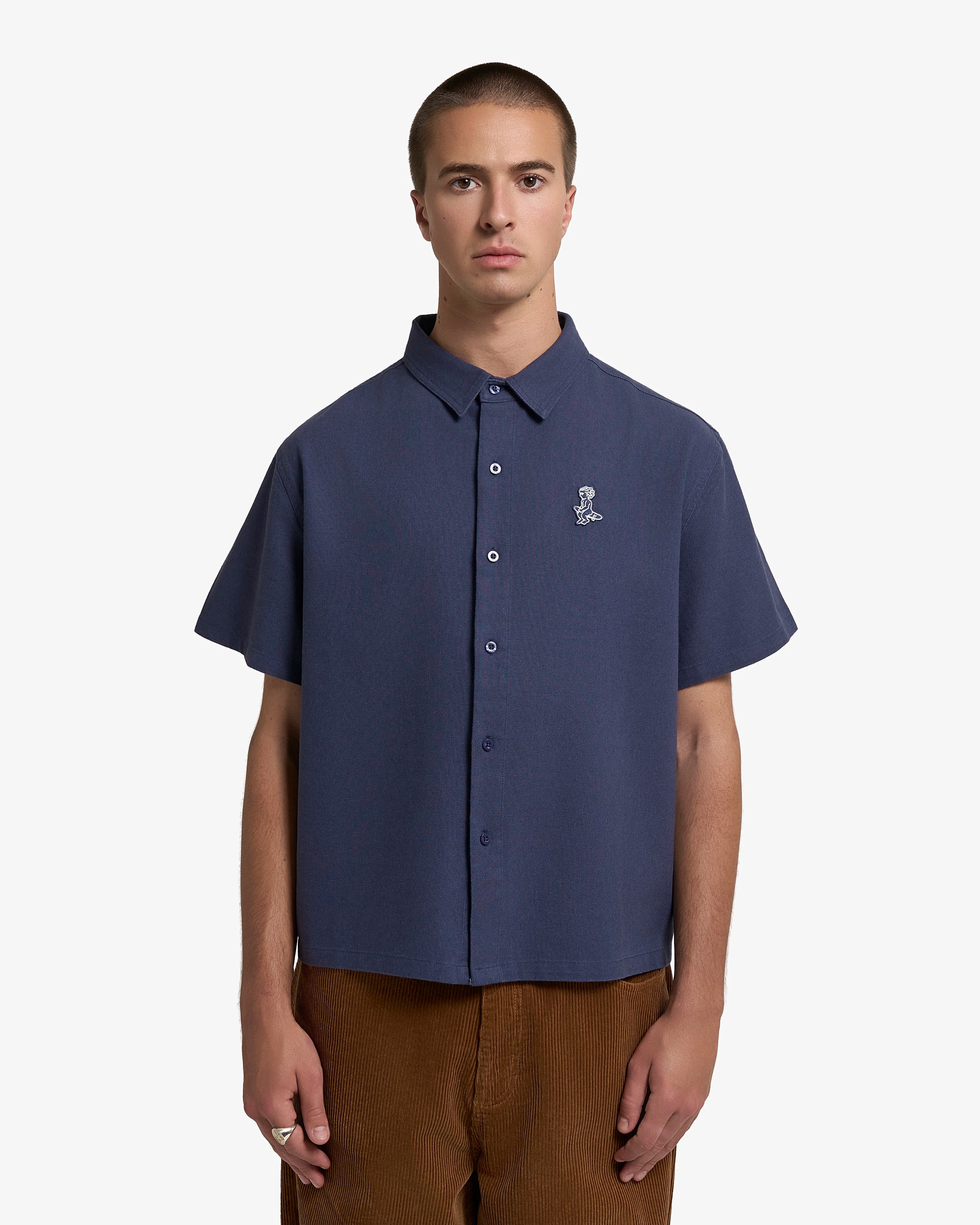 Short sleeve button-up shirt with a clean, structured appearance
100% cotton fabric with a textured weave and dry hand feel
Relaxed fit with a straight cut for ease of movement
Chest embroidered patch featuring the Ikon logo
Deep navy tone with a matte finish and tonal buttons