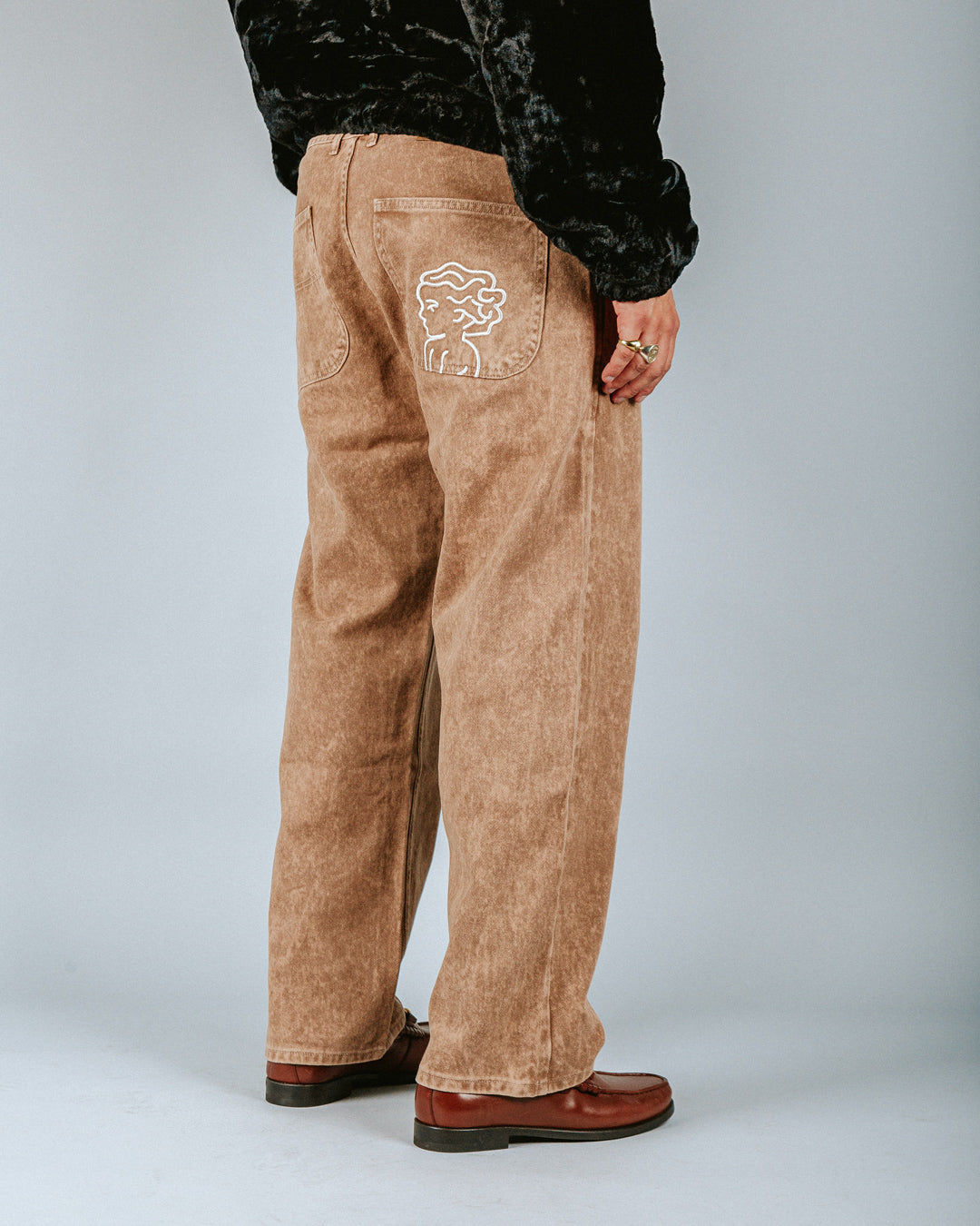 The Big Ikon Twill Relaxed Fit Pants are designed with a baggy, relaxed straight fit and a mid-waist, offering comfort and ease of movement. The pants are crafted from dyed camel rag on twill fabric, providing a unique and stylish color. They feature two front pockets and two back pockets.