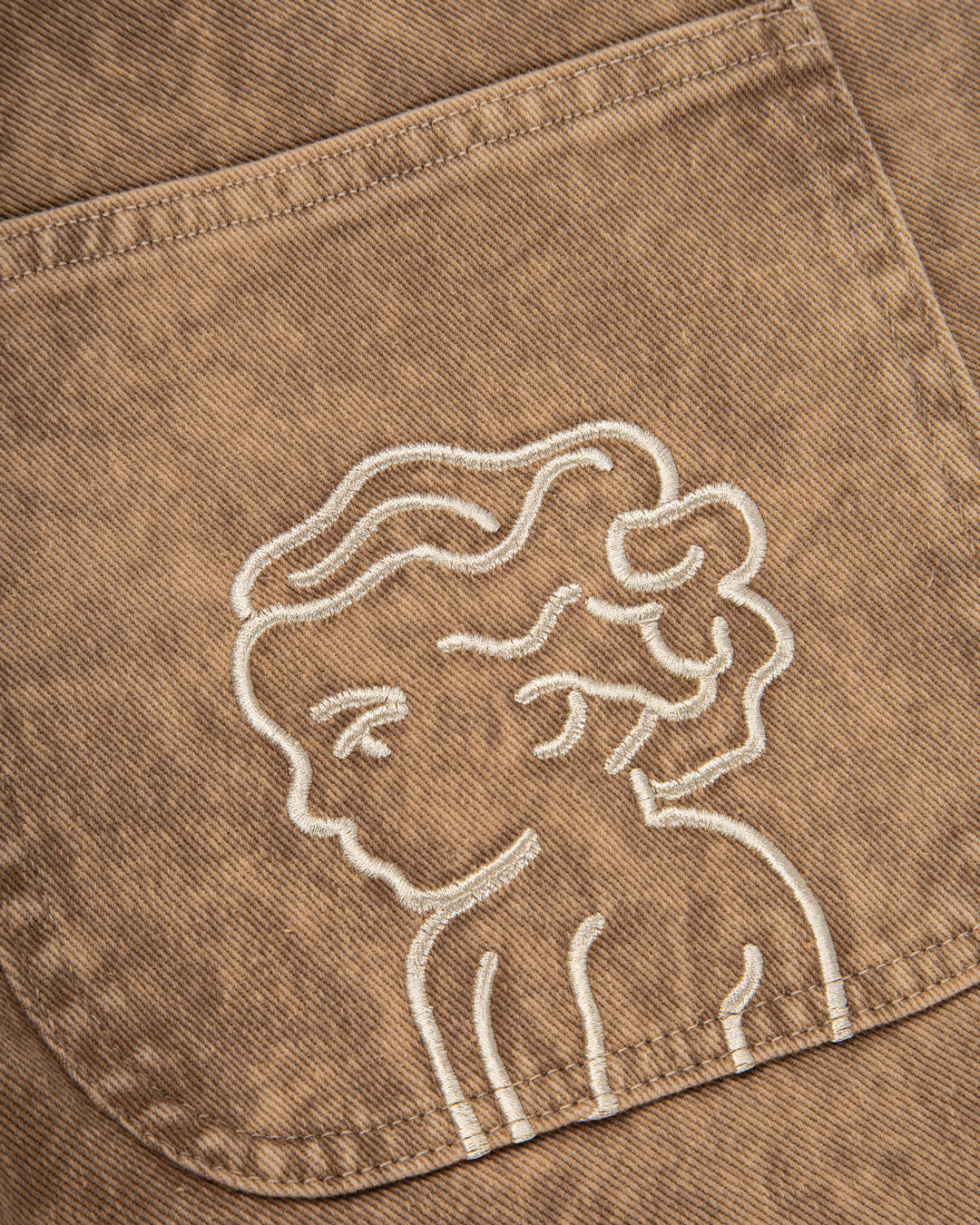 The Big Ikon Twill Relaxed Fit Pants are designed with a baggy, relaxed straight fit and a mid-waist, offering comfort and ease of movement. The pants are crafted from dyed camel rag on twill fabric, providing a unique and stylish color. They feature two front pockets, two back pockets, and one side pocket for practical storage.