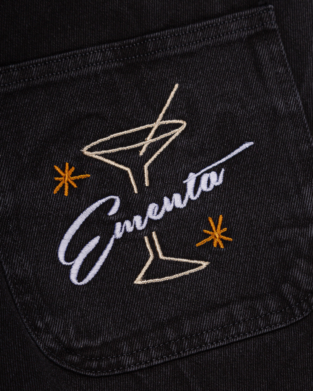 Relaxed-fit jeans made from black marble-washed denim, designed for comfort and durability with a focus on providing the perfect fit. The jeans feature the cocktail design embroidered on the back pocket for added detail. Equipped with two back pockets, two front pockets, and one side pocket for practical storage.