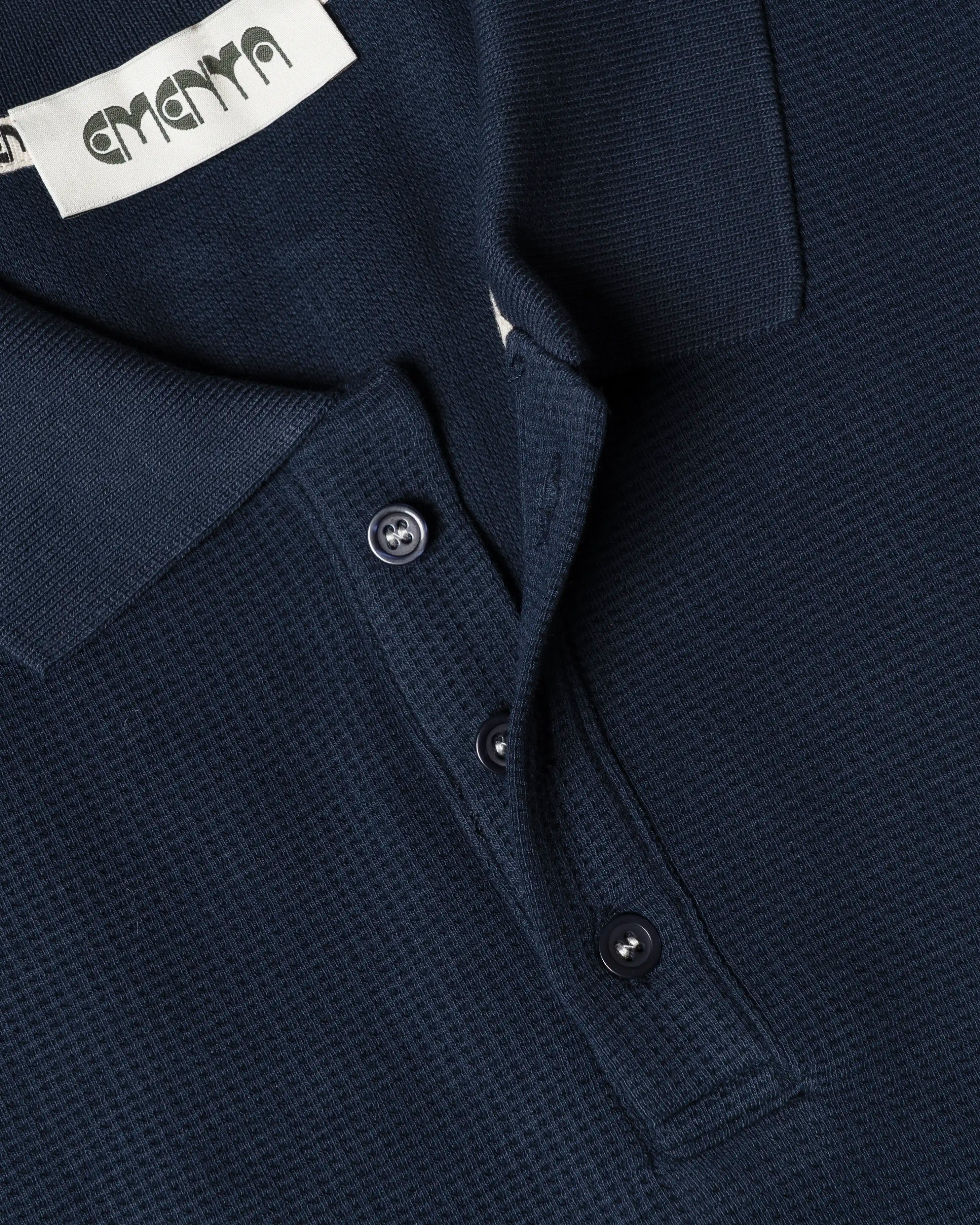 Ementa Polo Shirt
Waffle knit texture for enhanced breathability and structure
Embroidered Ikon logo on the chest
Button-up front with four tonal buttons
Ribbed collar and sleeves
100% cotton
Regular fit
Unisex
Made in Portugal