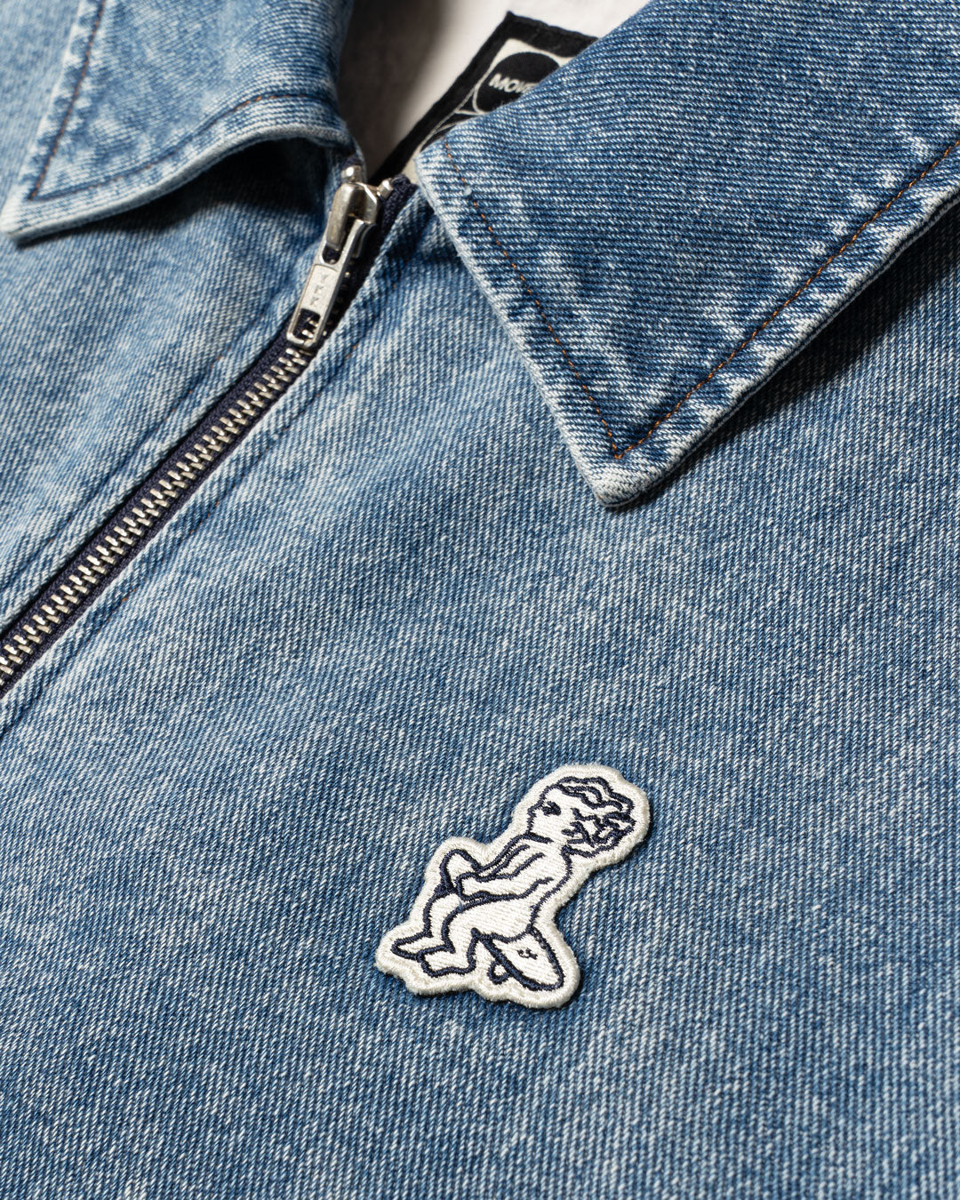 Cropped women's denim jacket with modern boxy fit
Signature "Moved by Friendship" motto subtly printed inside
Made in Portugal from 100% cotton denim
Distinct strong bleach blue fade wash for a worn-in vintage look
Embroidered chest Ikon logo patch
Two front-hand pockets for everyday practicality
Hidden interior pocket for secure storage
Full metal zipper front closure with branded pull
Classic pointed collar and reinforced topstitching
Made to be layered, styled, and lived in