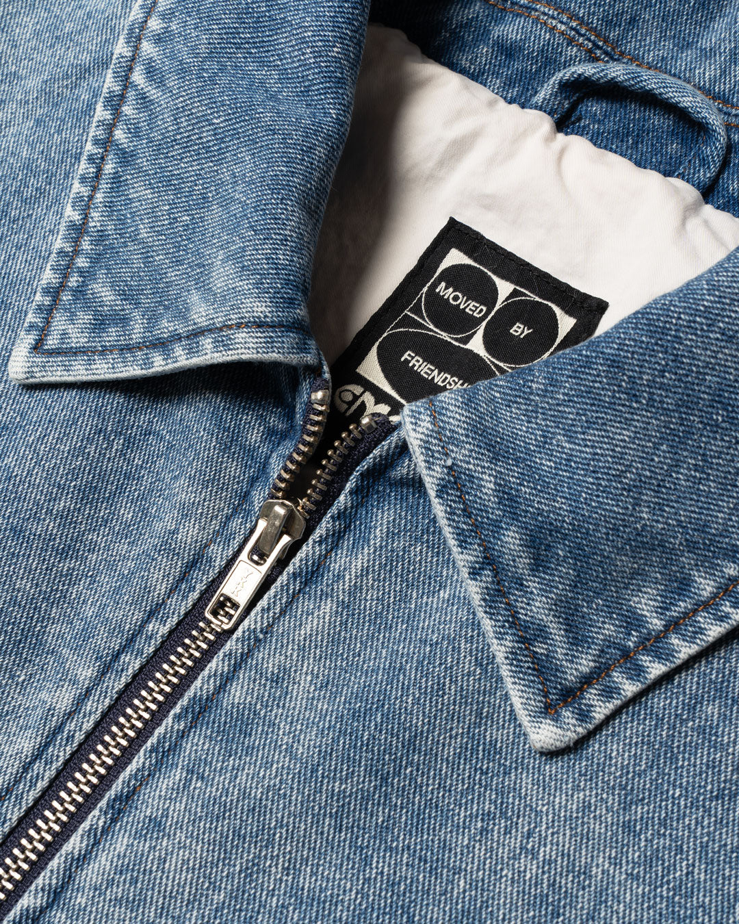 Cropped women's denim jacket with modern boxy fit
Signature "Moved by Friendship" motto subtly printed inside
Made in Portugal from 100% cotton denim
Distinct strong bleach blue fade wash for a worn-in vintage look
Embroidered chest Ikon logo patch
Two front-hand pockets for everyday practicality
Hidden interior pocket for secure storage
Full metal zipper front closure with branded pull
Classic pointed collar and reinforced topstitching
Made to be layered, styled, and lived in