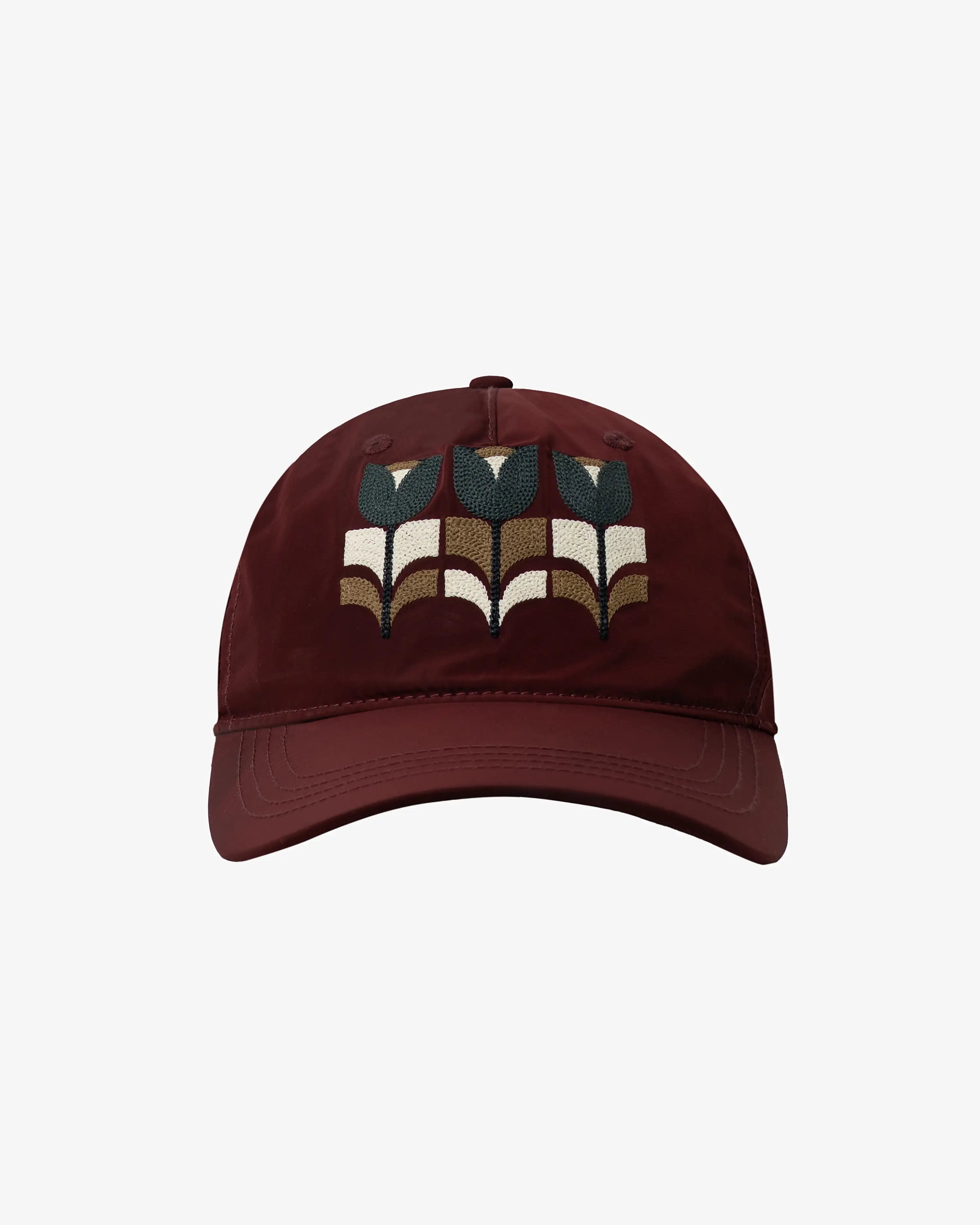 Six-panel cap designed for everyday wear.
Lightweight nylon fabric with a smooth finish and quick-drying feel.
Features a triple tulip embroidery inspired by the Flourish artwork on the front, with "Moved By Friendship" embroidery on the back.
Curved brim with an adjustable fabric strap and metal buckle for a customizable fit.
Burgundy finish with tonal stitching and multicolour embroidery details.
Made in Portugal.