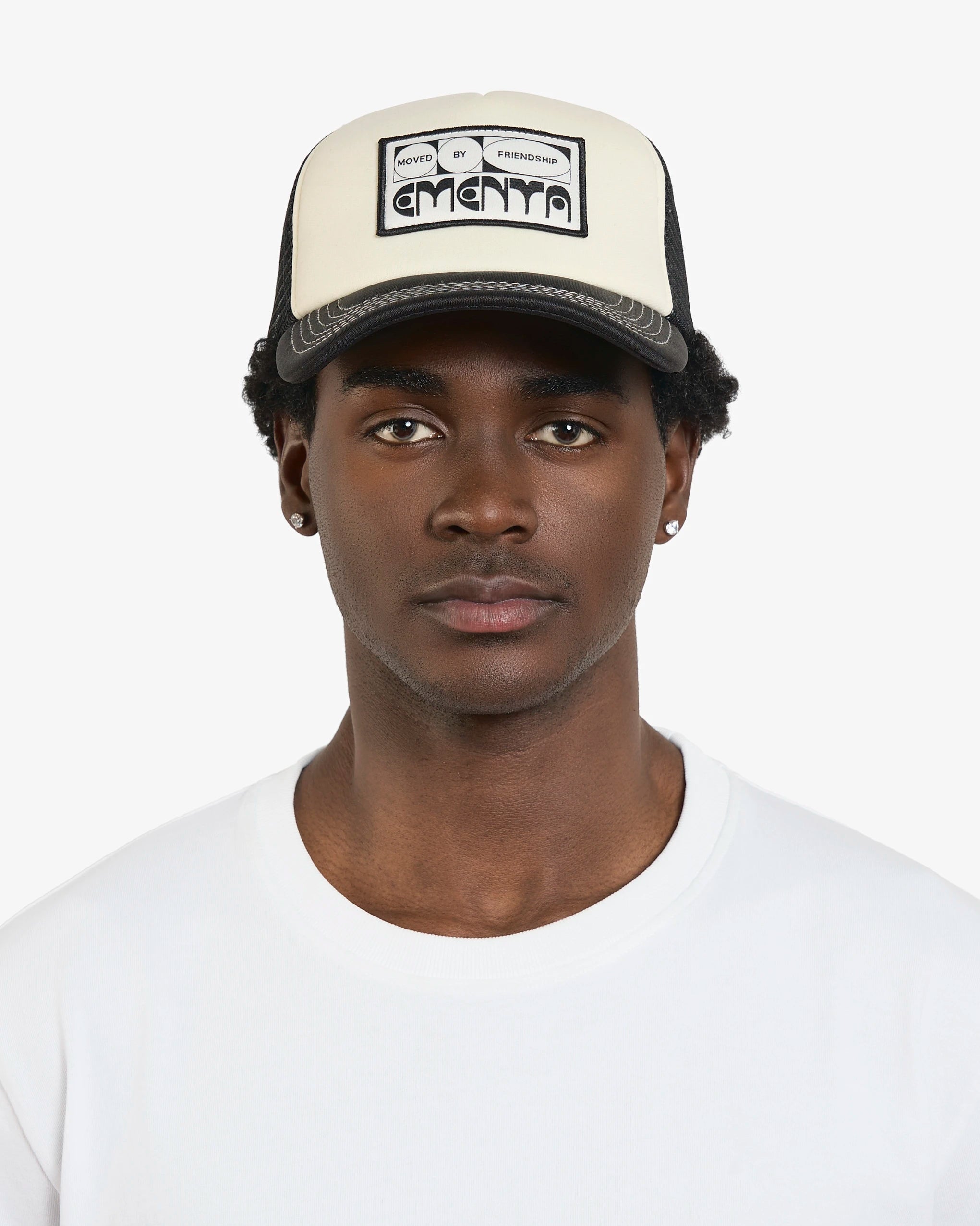 Cotton twill front panel with breathable black mesh for ventilation
Off-white front with black brim and mesh panels
Curved brim with visible white stitching
Features a ‘Moved By Friendship’ patch on the front
Adjustable back strap for a custom fit
Made in Portugal
