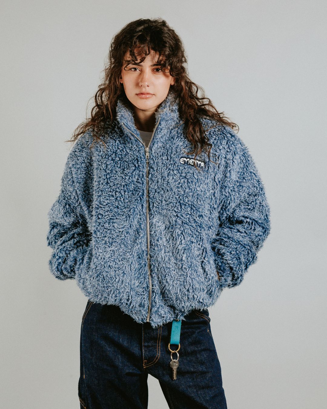 The Poncha Jacket is designed for warmth and comfort with its soft blue fur exterior. Inside, it features diamond stitching for added texture and durability.

It offers elasticated wrists and hips for a customizable fit, two exterior pockets and an interior pocket for convenient storage.