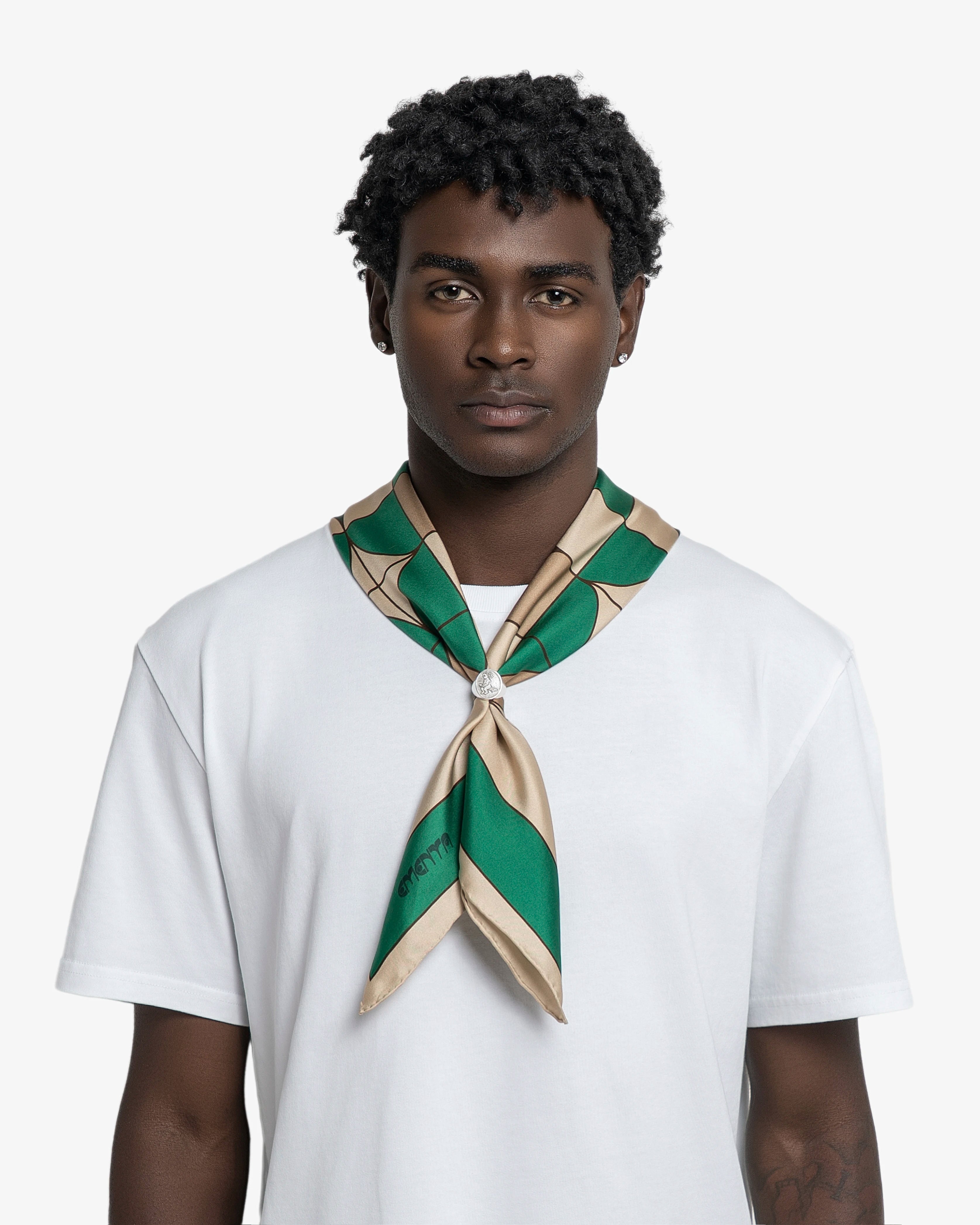 Silk scarf designed as a versatile accessory for styling around the neck, head or bag
Lightweight silk with a smooth, fluid hand feel
Square shape with a printed geometric pattern combining green, beige and dark brown tones
Origins artwork incorporates Ementa lettering, graphic symbols and repeated geometric forms
Finished with a contrasting green border framing the central pattern

90cmx90cm