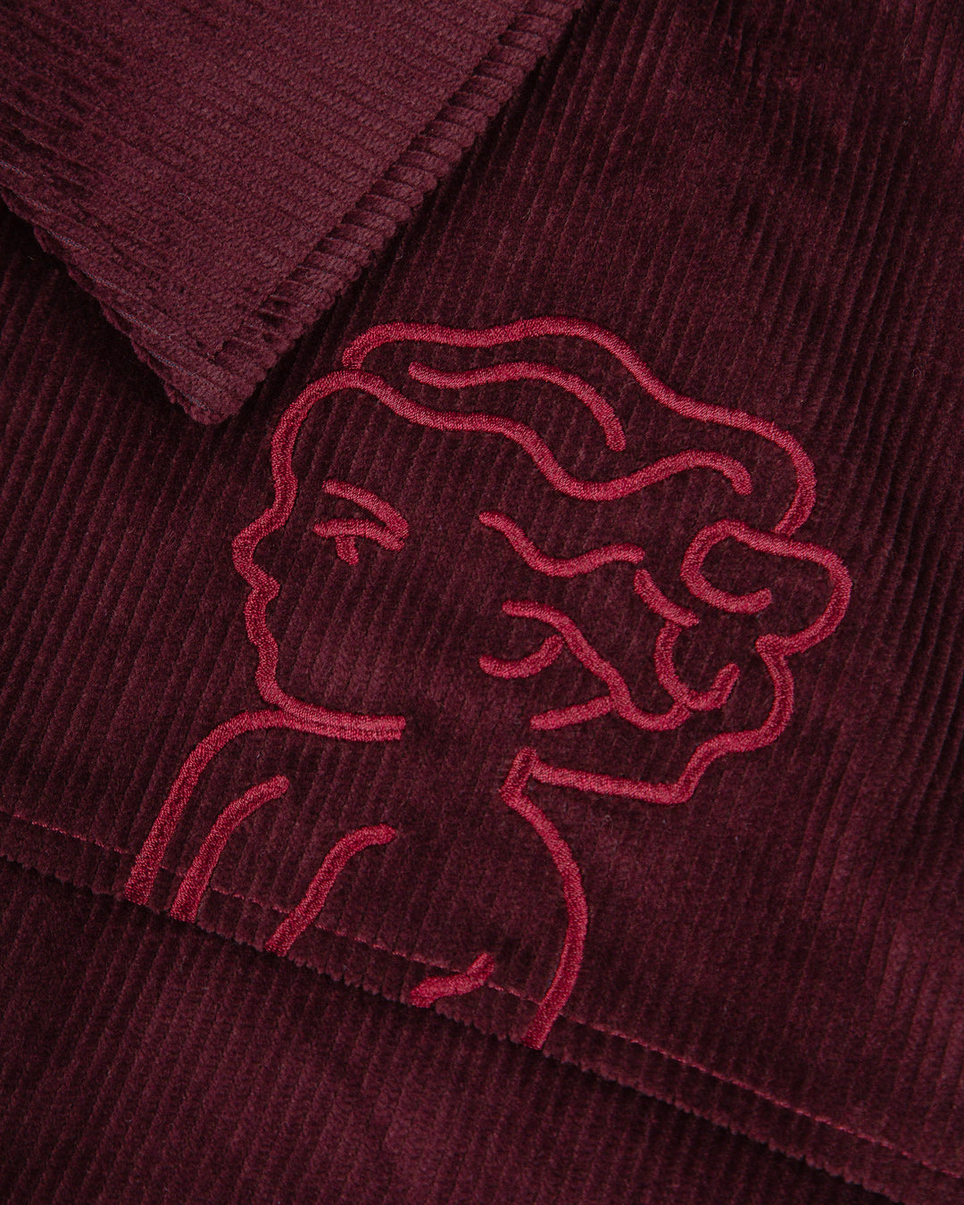The Big Ikon Corduroy Jacket is made from durable burgundy corduroy with a liquid-repellent coating, making it a reliable choice for various weather conditions. It features a puffed interior for warmth and comfort. On the chest, you'll find an embroidered Big Ikon logo, while the back showcases the motto "Moved by Friendship." The elasticated waist and cuffs provide an adjustable fit.