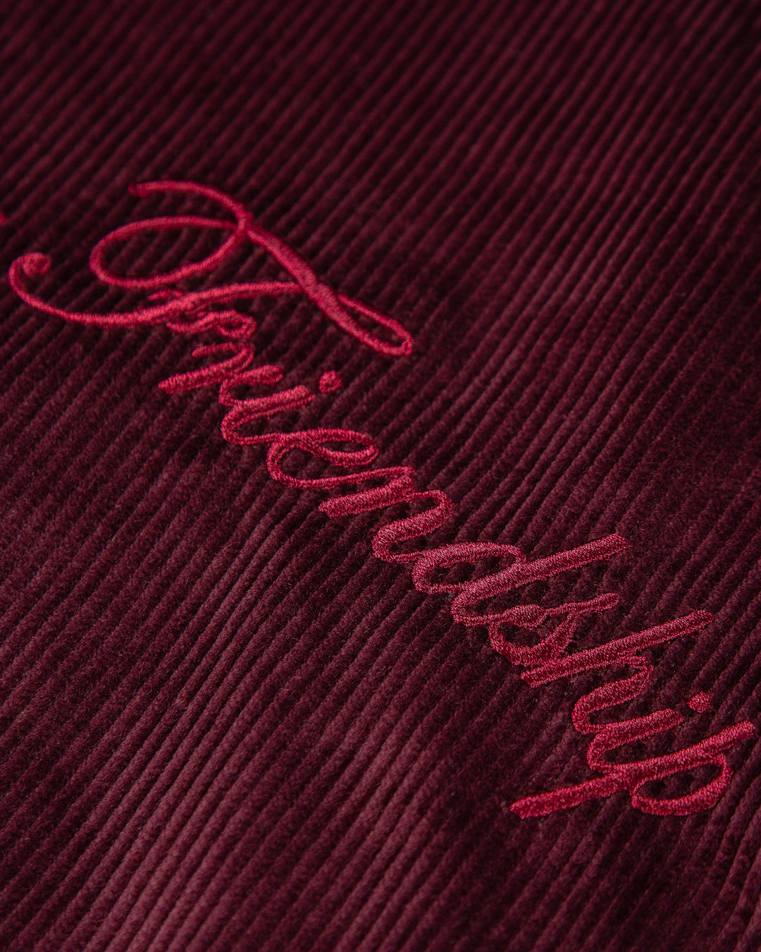 The Big Ikon Corduroy Jacket is made from durable burgundy corduroy with a liquid-repellent coating, making it a reliable choice for various weather conditions. It features a puffed interior for warmth and comfort. On the chest, you'll find an embroidered Big Ikon logo, while the back showcases the motto "Moved by Friendship." The elasticated waist and cuffs provide an adjustable fit.
