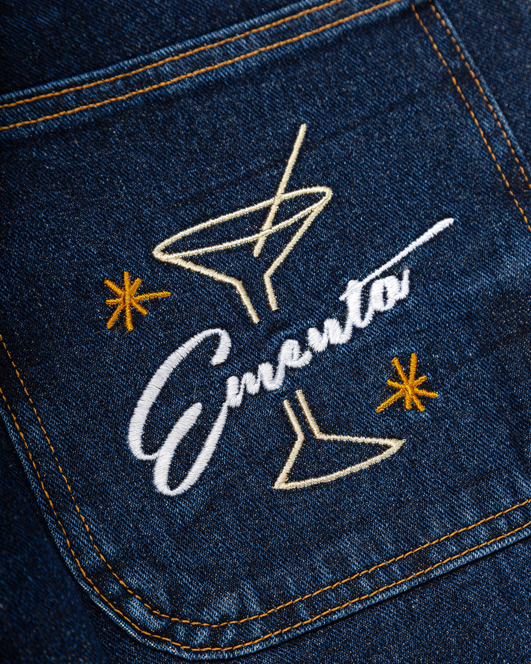 Relaxed-fit jeans made from blue marble stone-washed denim, designed for comfort and durability with a focus on providing the perfect fit. The jeans feature the cocktail design embroidered on the back pocket for added detail. Equipped with two back pockets, two front pockets, and one side pocket for practical storage.