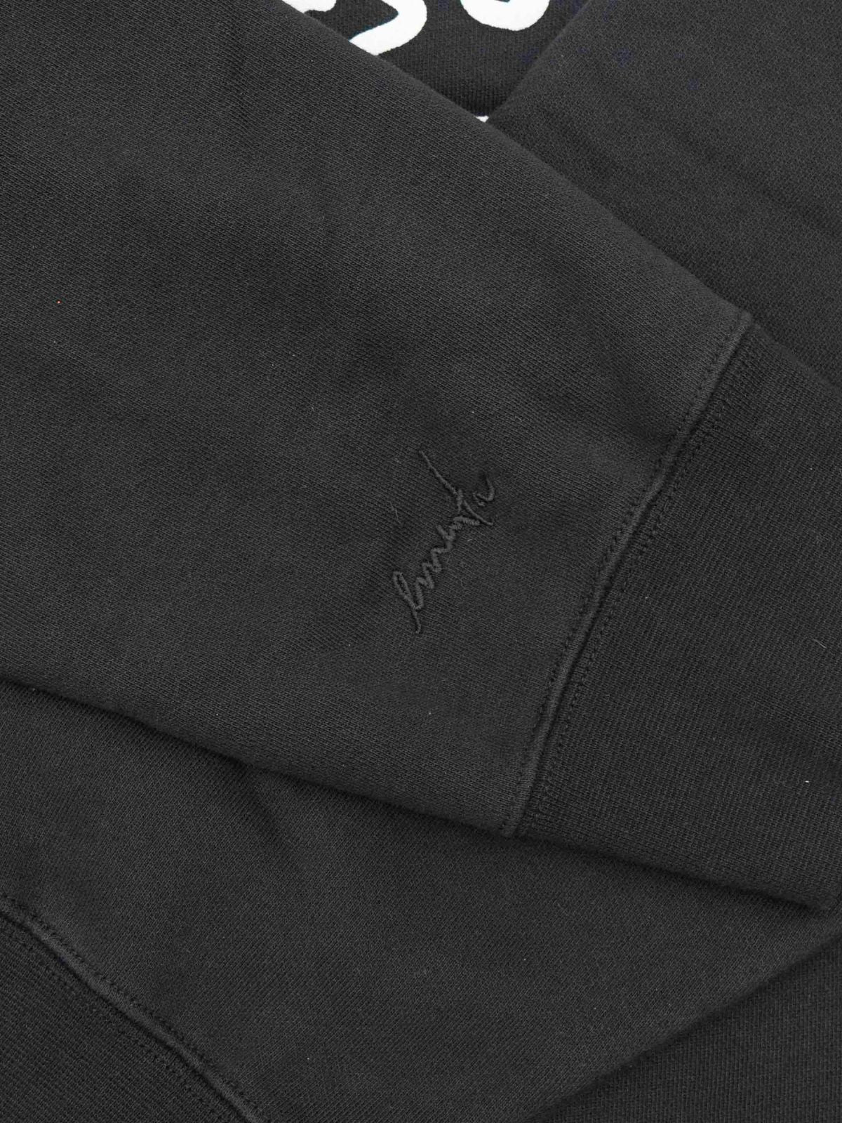 Crafted from heavyweight 100% cotton, this black hoodie is designed to hold its shape and resist frequent wear, offering durability and a cozy feel. The interior is lined with heavyweight brushed fleece for added warmth. It features an embossed print with a textured Ikon stamp and an embroidered signature on the right wrist.