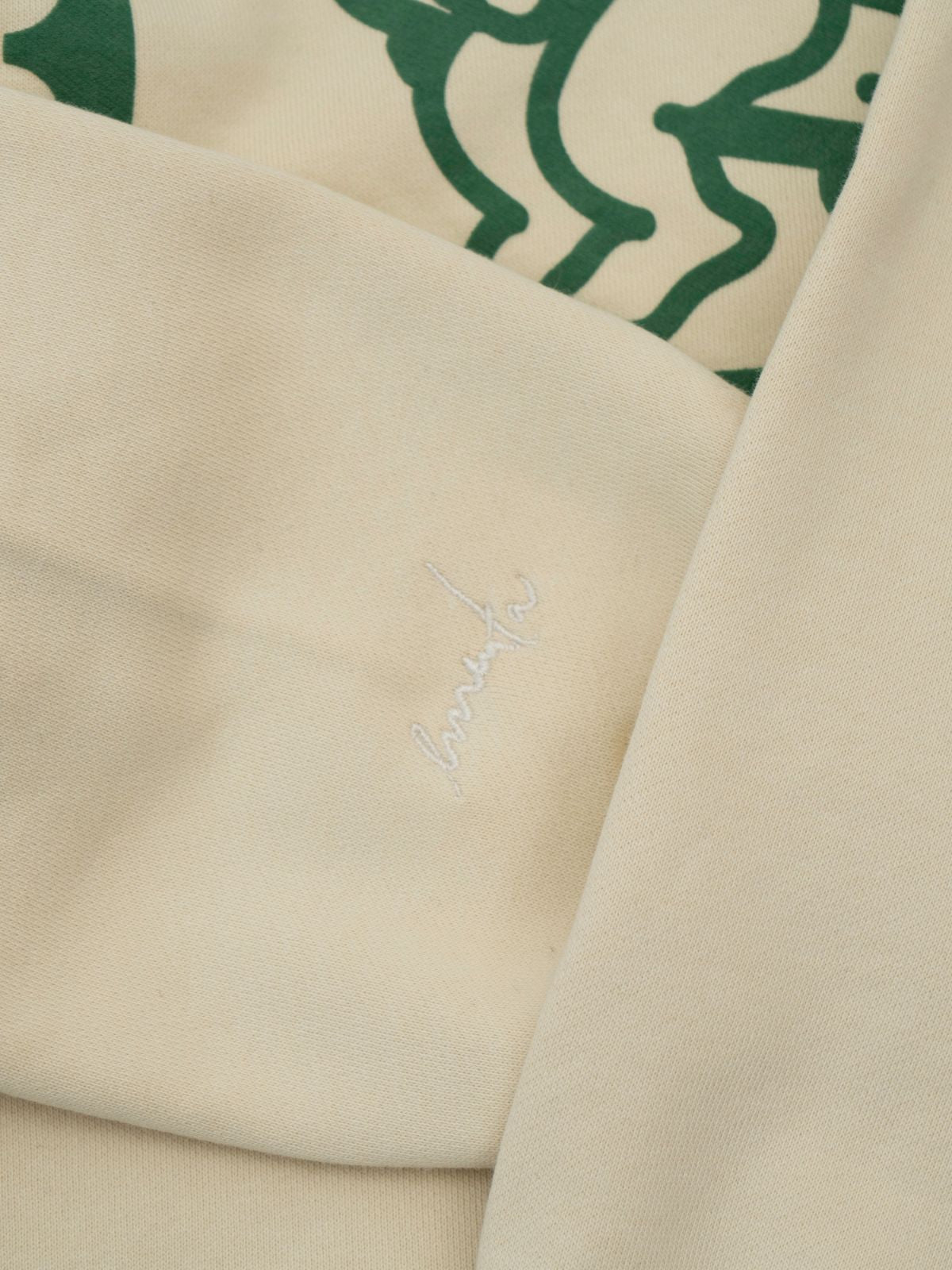 Crafted from heavyweight 100% cotton, this off-white hoodie is designed to hold its shape and resist frequent wear, offering durability and a cozy feel. The interior is lined with heavyweight brushed fleece for added warmth. It features an embossed print with a textured Ikon stamp and an embroidered signature on the right wrist.