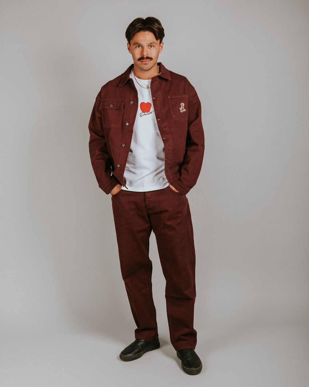 The Kit Ikon Twill Jacket in burgundy features a versatile and timeless design, made for durability and comfort.

Featuring a classic button-down front, a structured collar, wrist cuffs, chest pockets for functionality, and an embroidered design for added flair, this jacket is perfect for casual outings or workwear.