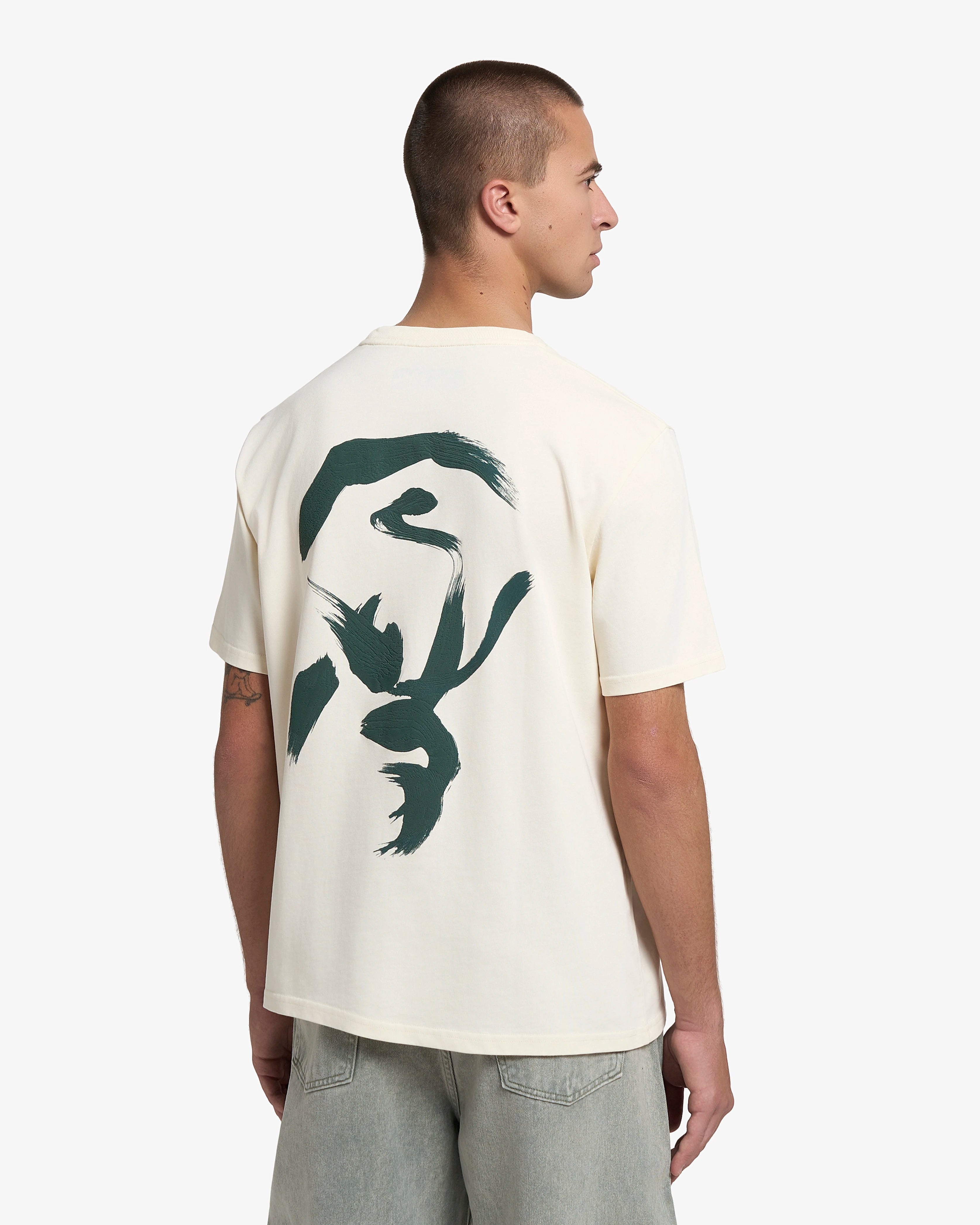 Artist edition featuring a hand-drawn design on the back, originally created on canvas&nbsp;
Short-sleeve t-shirt designed for everyday wear
Heavyweight 250 gsm 100% cotton jersey with a structured feel
Regular unisex fit
Off-white base colour with green graphic print on the front and back
Made in Portugal