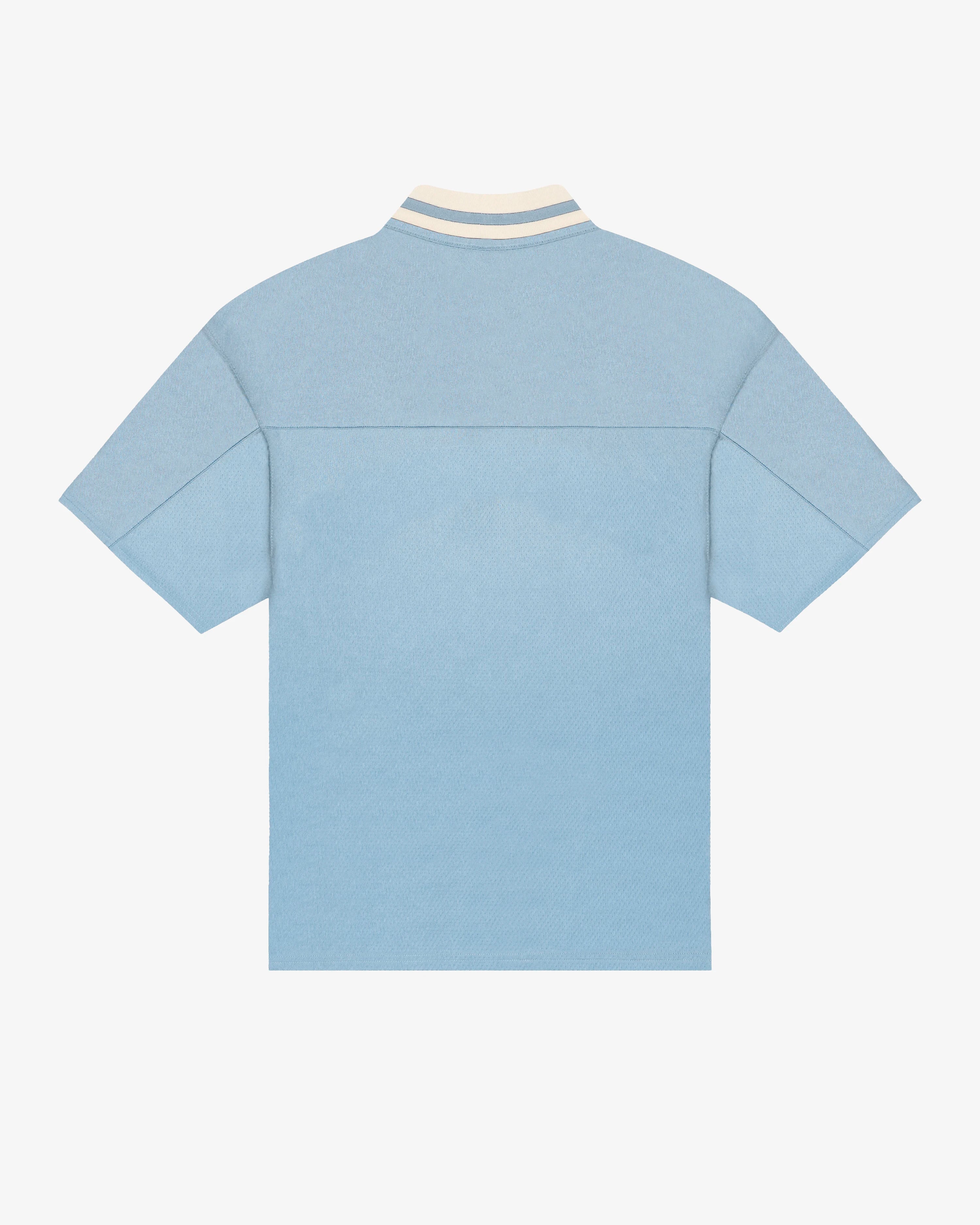 Breathable mesh fabric on the lower half, cotton-poly blend on the upper half
Oversized fit
Sky blue color with off-white accents
Large 'EMENTA' embroidery on the chest, small branded detail embroidered on the bottom right
V-neck collar with double green stripes
Oversized sleeves for a relaxed silhouette
Part of a kit – matching shorts available online
Machine washable