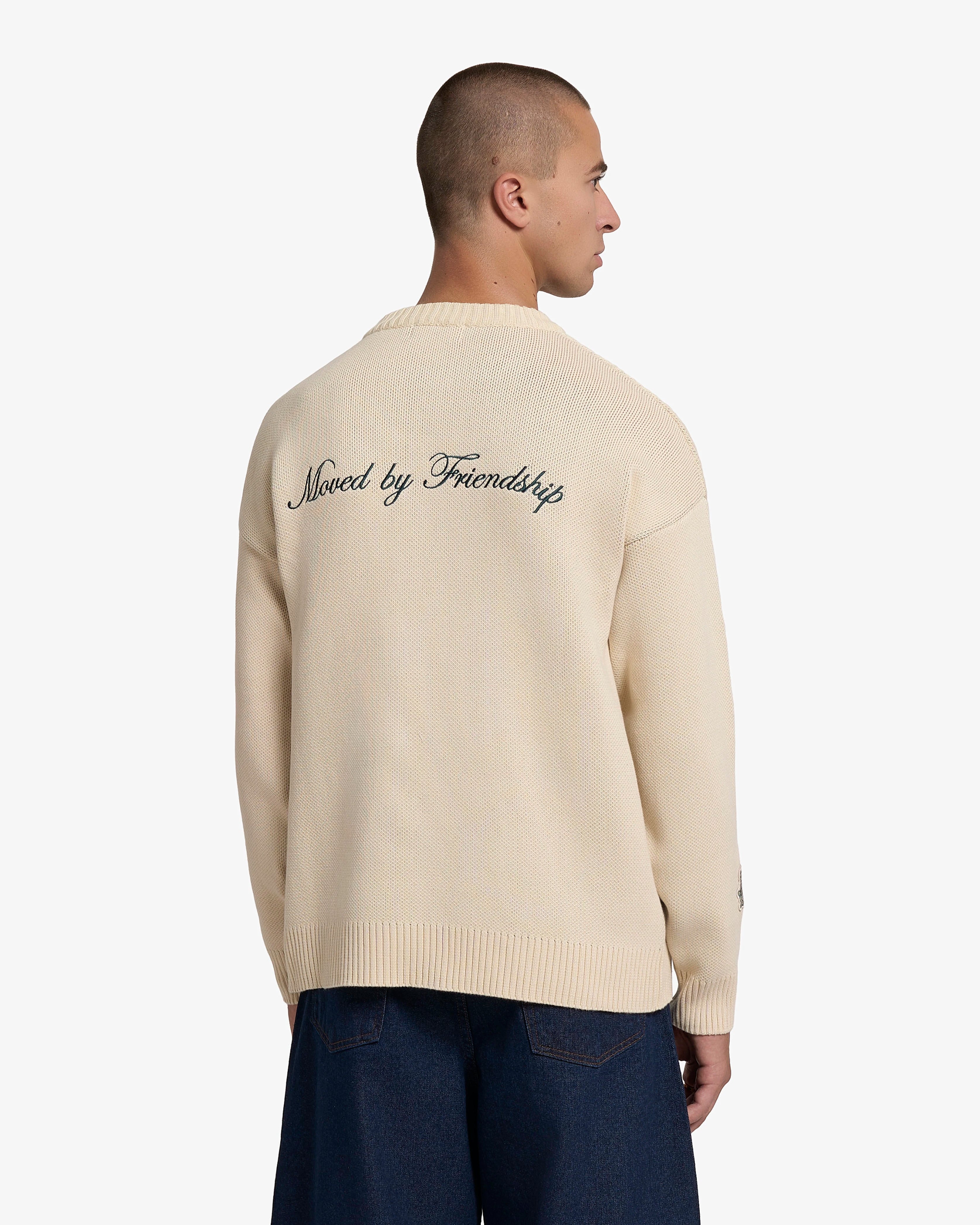 Knitted crewneck sweater designed for everyday wear and layering
100% cotton knit with a structured texture and soft hand feel
Regular fit with ribbed collar, cuffs and hem
‘Moved By Friendship’ motto embroidered in evergreen across the back
Off-white colour
Machine wash cold. Do not tumble dry
Made in Portugal