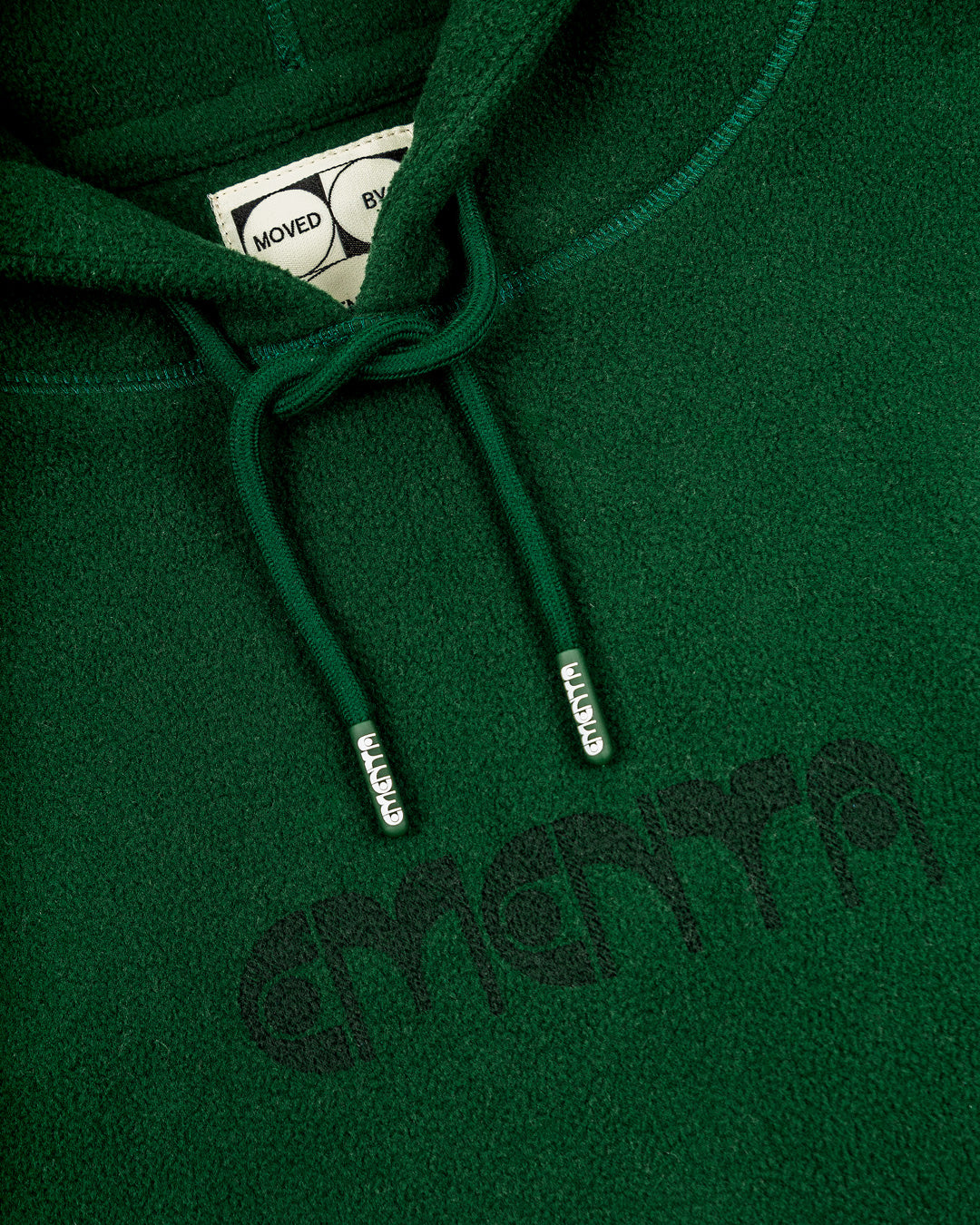 Polar hoodie with a baggy fit, designed for ultimate comfort and warmth. The front features the Ementa logo, while the back showcases the motto, "Moved by Friendship." It also includes a branded hoodie lace, adjustable cuffs, and waist, and two zips on the front pocket, making it both practical and cozy.